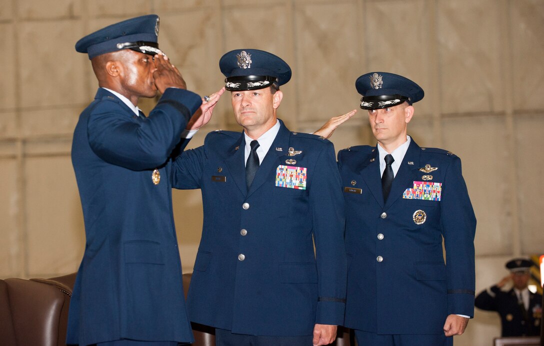 Col. Ken Rizer, 11th Wing/Joint Base Andrews commander, center, and Col. Bill M. Knight, right, render a salute to Maj. Gen. Darren W. McDew, Air Force District of Washington commander, during the 11th Wing Change of Command ceremony held in Hangar 3 here July 6. (Photo/Bobby Jones)