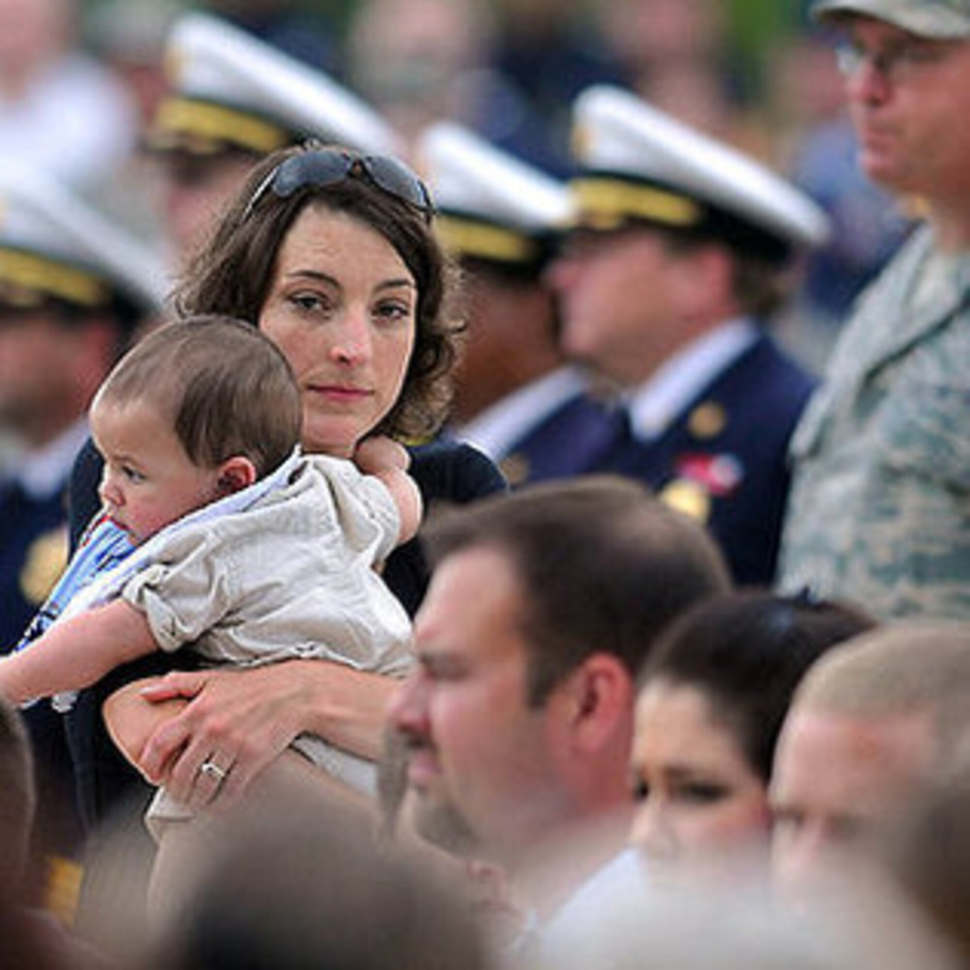 Jenny Ellerbe carries her six month old son, Rob, during a memorial service for her husband, Maj. Ryan David, and three other North Carolina Air National Guard Airmen July 10 in Charlotte, N.C. Lt. Col. Paul Mikeal, Maj. Joseph McCormick, Maj. Ryan David and Senior Master Sgt. Robert Cannon all died July 1 when their C-130 crashed while fighting a wildfire in the South Dakota Black Hills. Two aircrew were injured. (Courtesy photo/Charlotte Observer)