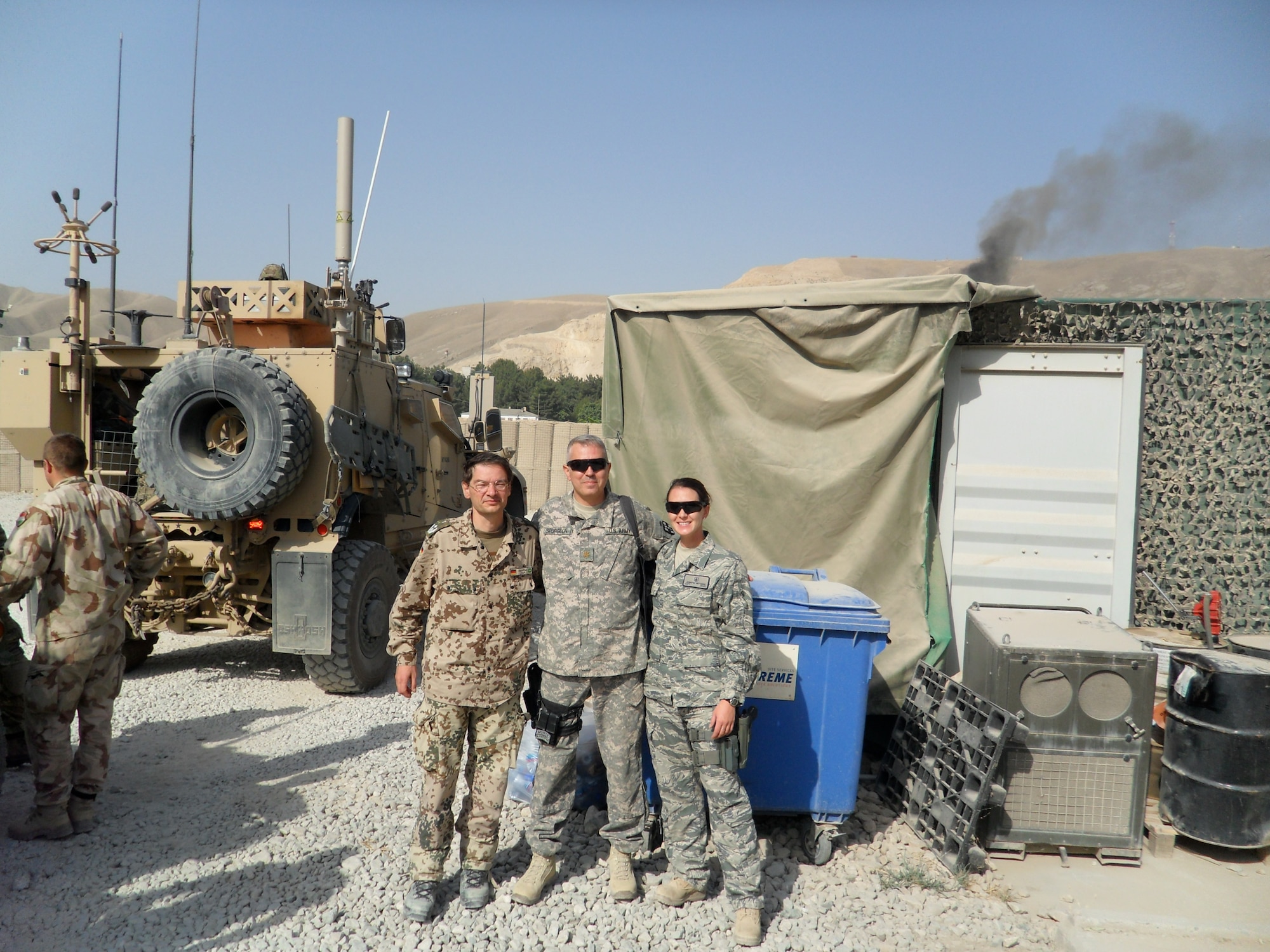 U.S. Air Force Capt. Jennifer Mitchum, 20th Medical Operations Squadron clinic nurse and flight chief at the Family Health Clinic, poses with U.S. Army Maj. John Spurgeon, 2nd Forward Surgical Team chief nurse, and a German surgeon at Combat Outpost Khilagay, Afghanistan, August 4, 2011. The German worked with a Special Operations Unit that was located at the COP. He would occasionally assist the 2nd FST with surgeries and mass casualty incidences. (Courtesy photo)