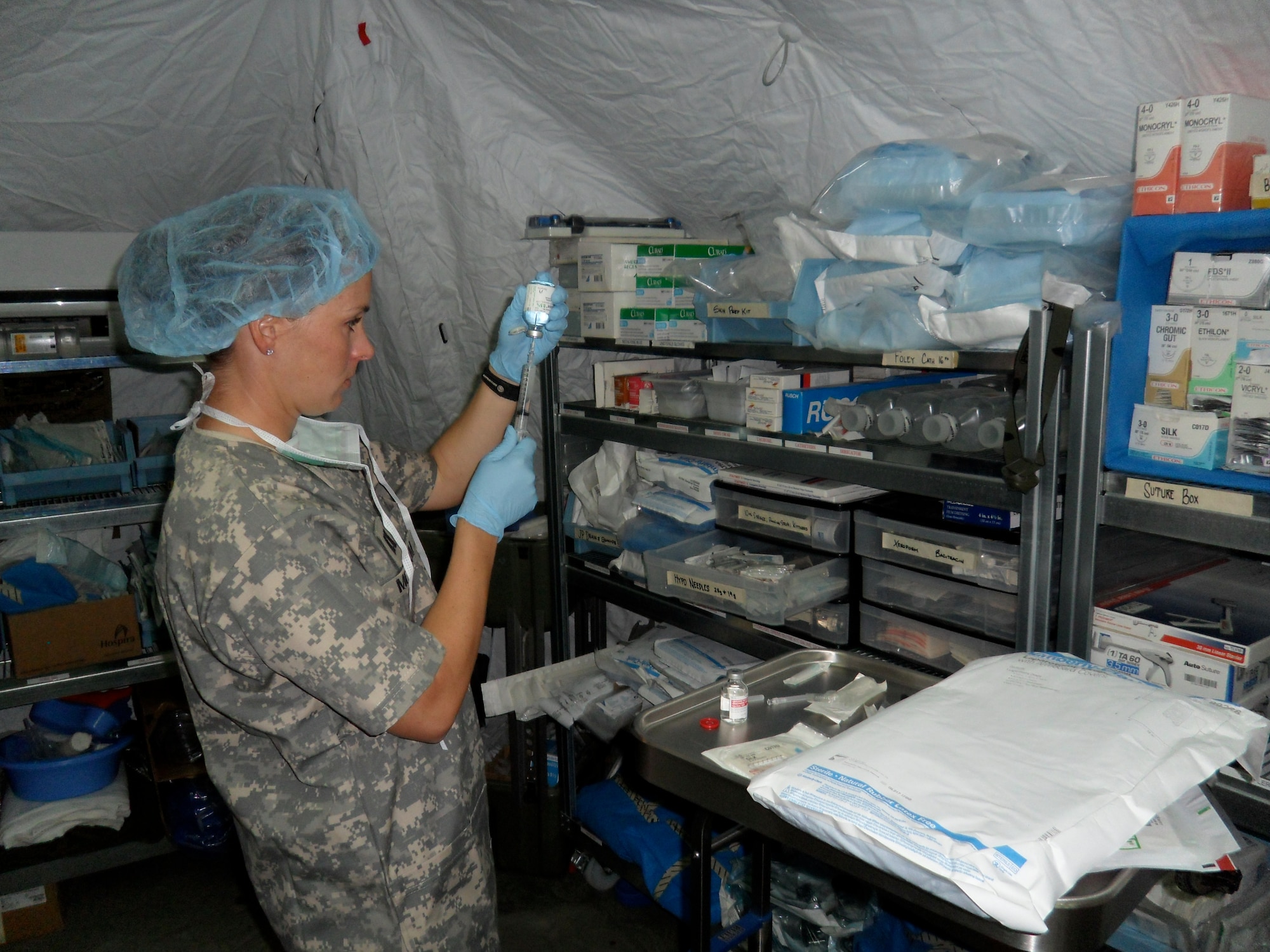 U.S. Air Force Capt. Jennifer Mitchum, 20th Medical Operations Squadron clinic nurse and flight chief at the Family Health Clinic, prepares for surgery at Combat Outpost Khilagay, Afghanistan, July 12, 2011. The medicine was used to numb the area the doctors would be operating on. Their patients included victims from gun shots, improvised explosive device blasts, and suicide bombers. (Courtesy photo)
