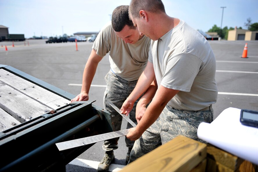 U.S. Air Force Tech. Sgt. Chad Wallace, 20th Logistics Readiness Squadron vehicle operations control center supervisor, and Staff Sgt. Jonathan Vanderford, 20th LRS equipment support supervisor, checks the distance of a 10-ton tractor with a 25 foot trailer from a simulated dock during the first-ever quarterly vehicle rodeo competition at Shaw Air Force Base, S.C., July 6, 2012. The tractor trailer event required competitors to back up through an obstacle course, and evenly merge with a dock while only relying on a spotter for direction. (U.S. Air Force photo by Senior Airman Amber E. N. Jacobs/Released)