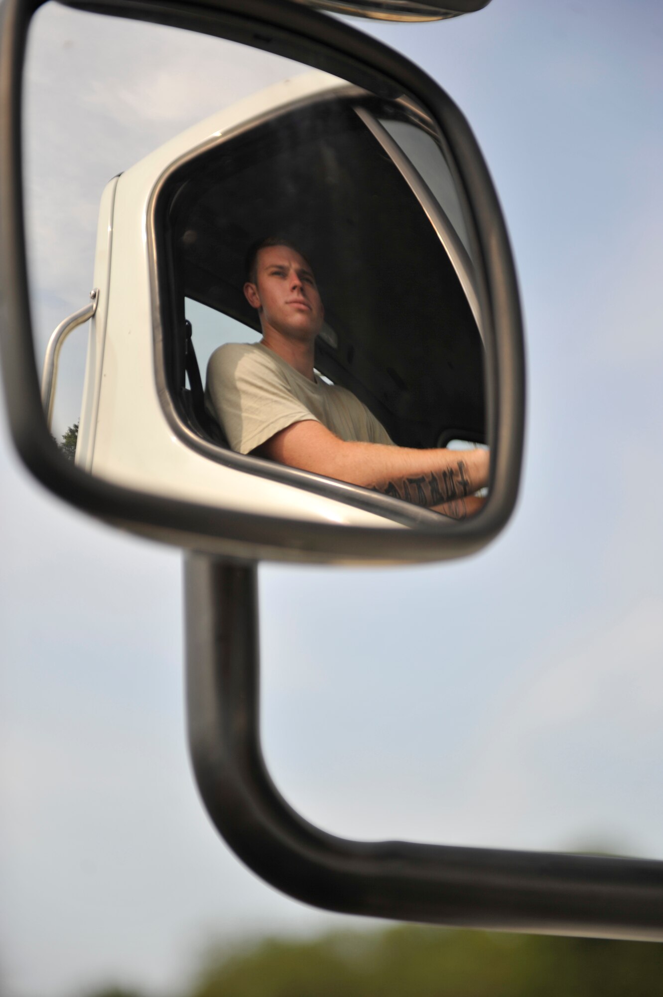U.S. Air Force Airman 1st Class Zachary Lakatos, 20th Logistics Readiness Squadron vehicle operator, checks the mirror of a 10-ton tractor with a 25 foot trailer while waiting for his partner to direct him during the first-ever quarterly vehicle rodeo competition at Shaw Air Force Base, S.C., July 6, 2012. The tractor trailer event required competitors to back up through an obstacle course, and evenly merge with a dock while only relying on a spotter for direction. (U.S. Air Force photo by Senior Airman Amber E. N. Jacobs/Released)