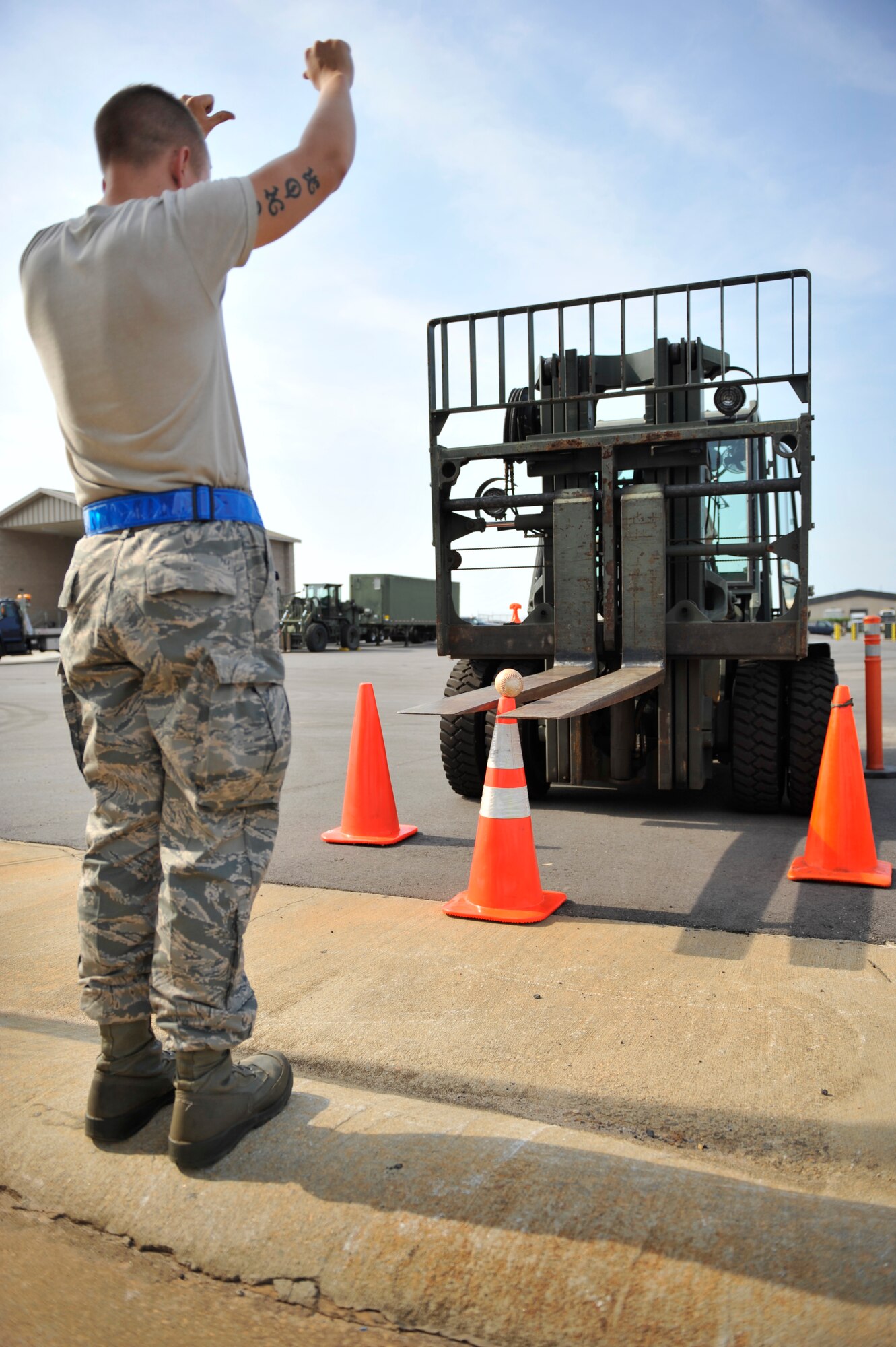 U.S. Air Force Senior Airman Nicholas Bucci, 20th Logistics Readiness Squadron vehicle operator, directs his partner Staff Sgt.  Matthew Roberts, 20th LRS NCOIC of wing validations, to move the forks of a 10K standard forklift in closer during the first-ever quarterly vehicle rodeo competition at Shaw Air Force Base, S.C., July 6, 2012. The forklift event required competitors to pick-up a softball only using the forks of the vehicle, maneuver it backwards through an obstacle course, and place the ball onto a traffic cone while relying on their spotters to direct them. (U.S. Air Force photo by Senior Airman Amber E. N. Jacobs/Released)