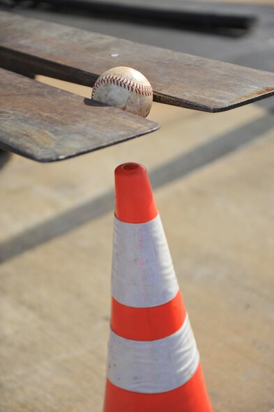 An Airman assigned to the 20th Logistics Readiness Squadron uses a 10K standard forklift to lower a softball onto a traffic cone during the first-ever quarterly vehicle rodeo competition at Shaw Air Force Base, S.C., July 6, 2012. The forklift event required competitors to pick-up a softball only using the forks of the vehicle, maneuver it backwards through an obstacle course, and place the ball onto a traffic cone while relying on their spotters to direct them. (U.S. Air Force photo by Senior Airman Amber E. N. Jacobs/Released)