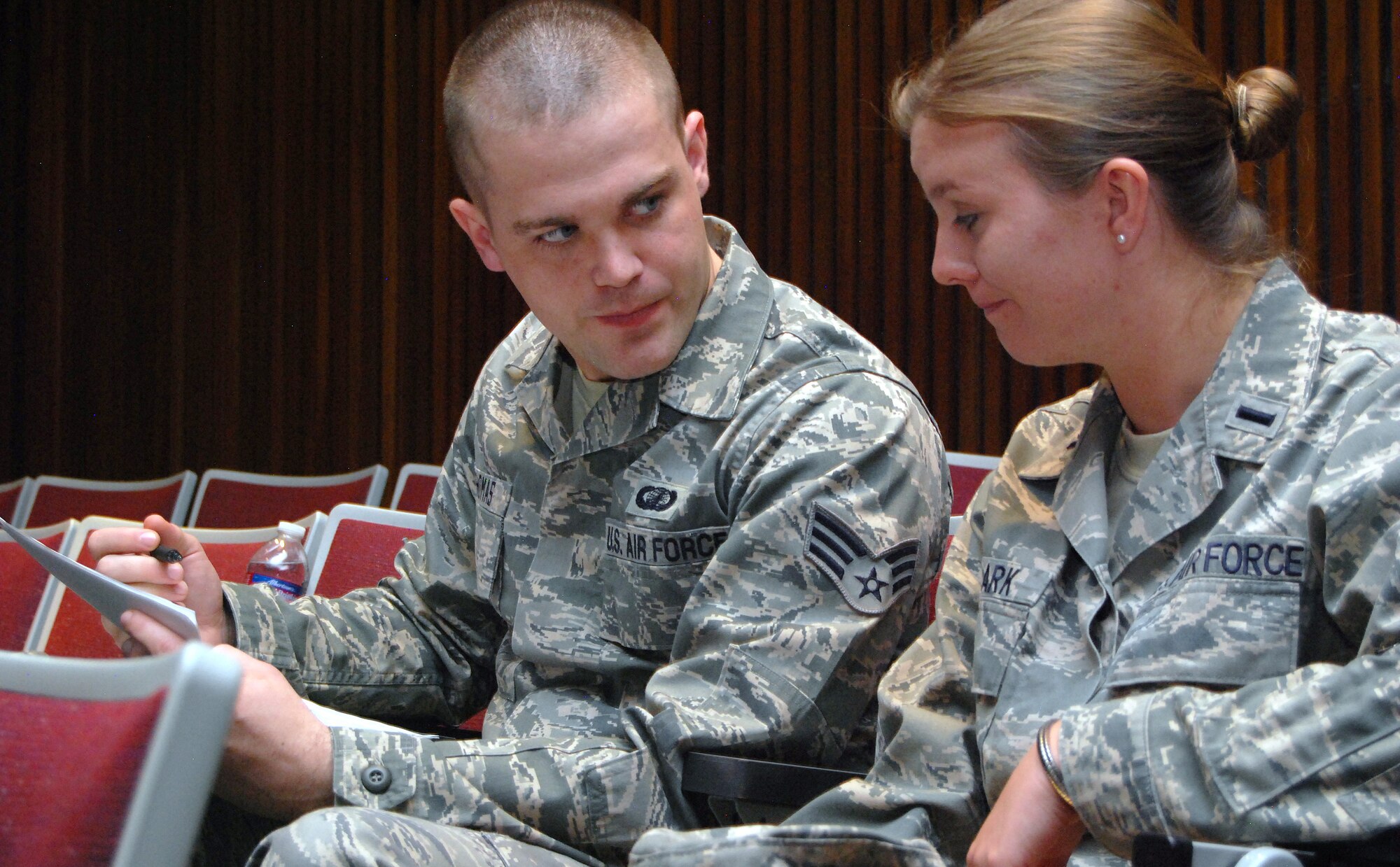 Senior Airman Joshua Thomas reviews 1st Lt. Rachael Clark's travel voucher as part of a processing line set up for Air Force Academy base housing residents July 9, 2012. More than 600 families were evacuated from the Academy June 26-29 due to the Waldo Canyon Fire, which burned 18,000 acres of forest and 346 homes south of the base. Thomas is a finance specialist with the 21st Space Wing at Peterson Air Force Base. Clark is assigned to the Academy's Economics and Geosciences Department. (U.S. Air Force photo/Don Branum)