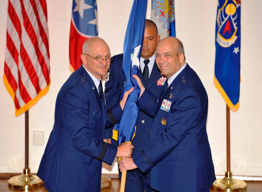 Brig. Gen. Arnold Bunch (left), Air Force Test Center commander, hands Brig. Gen. Michael Brewer his personal flag after Brewer is promoted to brigadier general, July 6 at Arnold Air Force Base, Tenn. During that same day, Brewer relinquished his command of Arnold Engineering Development Complex and became commander of the 412th Test Wing July 13 during a change of command ceremony at Edwards AFB, Calif.  (Air Force photo by Rick Goodfriend)
