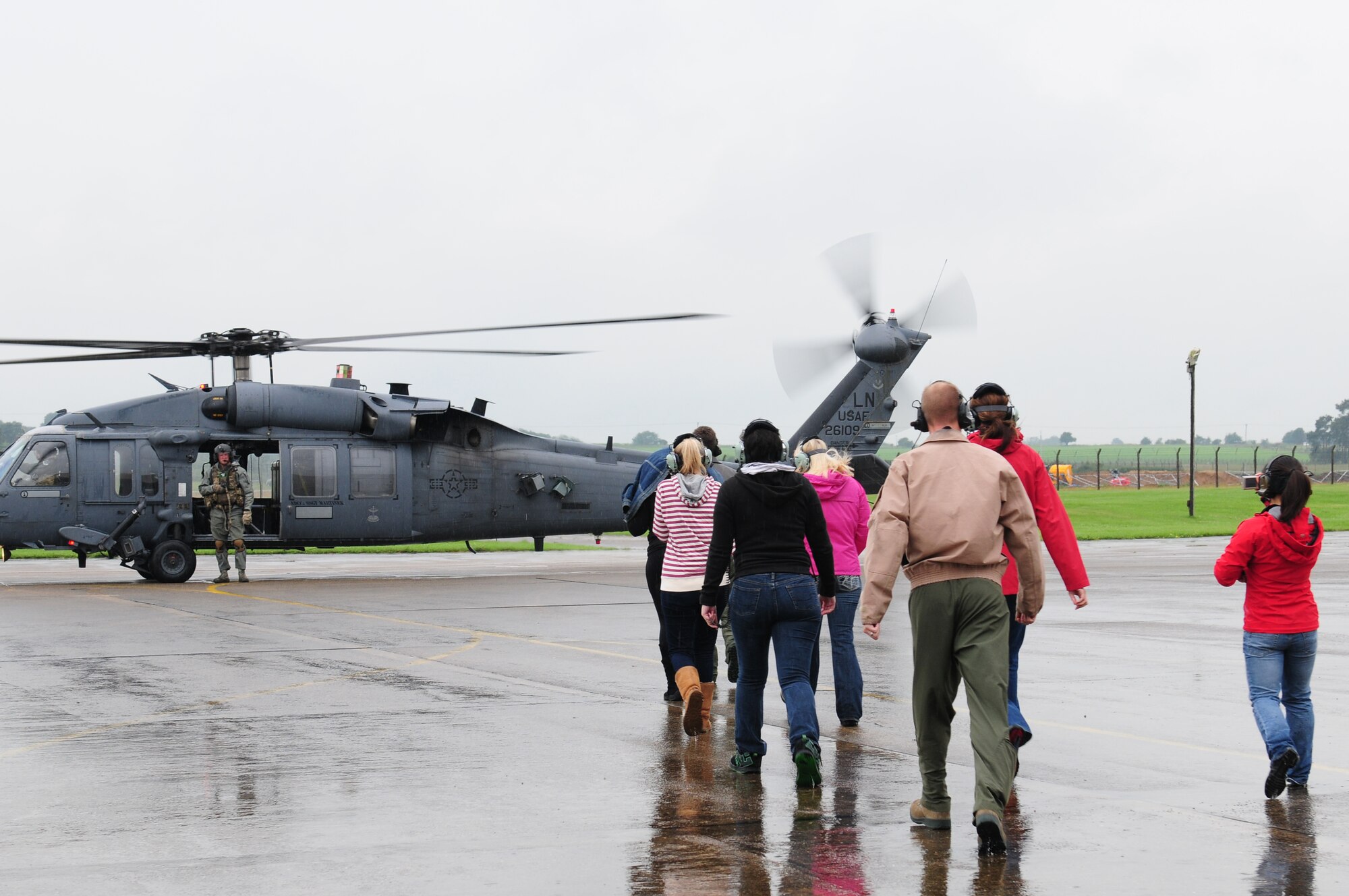 ROYAL AIR FORCE LAKENHEATH, England – Family members of Airmen from the 56th Rescue Squadron walk out to a HH-60G Pave Hawk before their flight during the 56th RQS spouses’ day July 6, 2012. The 56th RQS hosted a day at the squadron featuring incentive flights for more than 50 family members as well as jumping castles and coloring activities for children. (U.S. Air Force photo by Airman 1st Class Cory D. Payne)