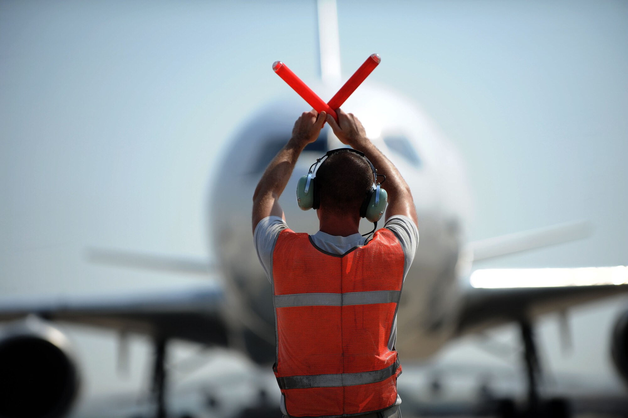 Staff Sgt. Tyler Wasson, 735th Air Mobility Squadron aerospace propulsion mechanic, marshals a World Air MD-11 passenger airplane July 10, 2012, at Incirlik Air Base, Turkey. Wasson is deployed to Incirlik from Joint Base Pearl Harbor-Hickam, Hawaii. Wasson is attached to the 728th AMS maintenance flight, which provides maintenance and supply support for Air Mobility Command military and commercial aircraft missions. (U.S. Air Force photo by Senior Airman Jarvie Z. Wallace/Released)
