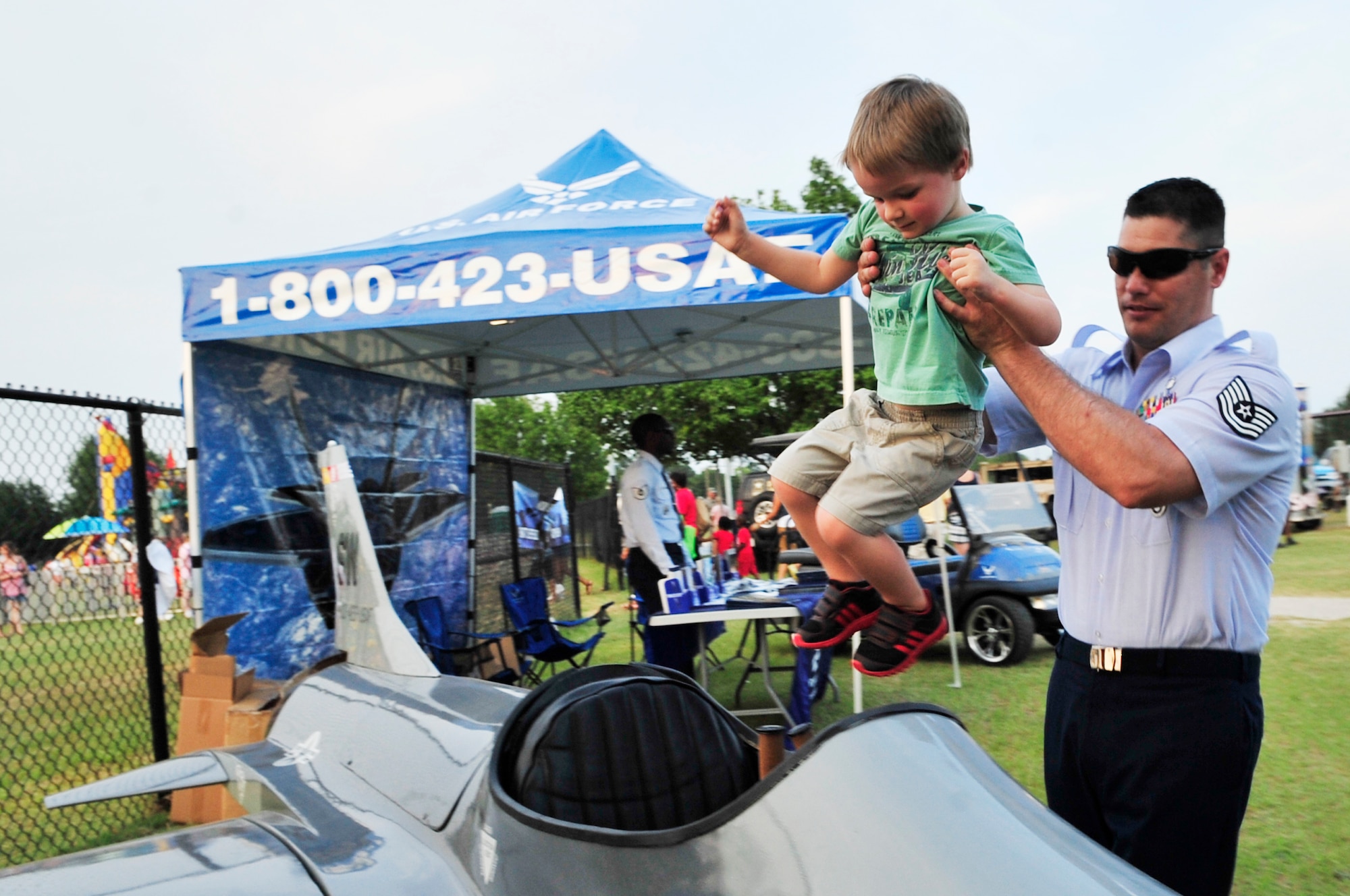 U.S. Air Force recruiters give children the opportunity to sit in a miniature version of an F-16 Fighting Falcon at the Jammin July Fourth, at Dillon Park, Sumter, S.C., July 4, 2012.  Shaw Air Force Base funded the fireworks display for the Sumter community.(U.S. Air Force photo by Airman Nicole Sikorski/Released)