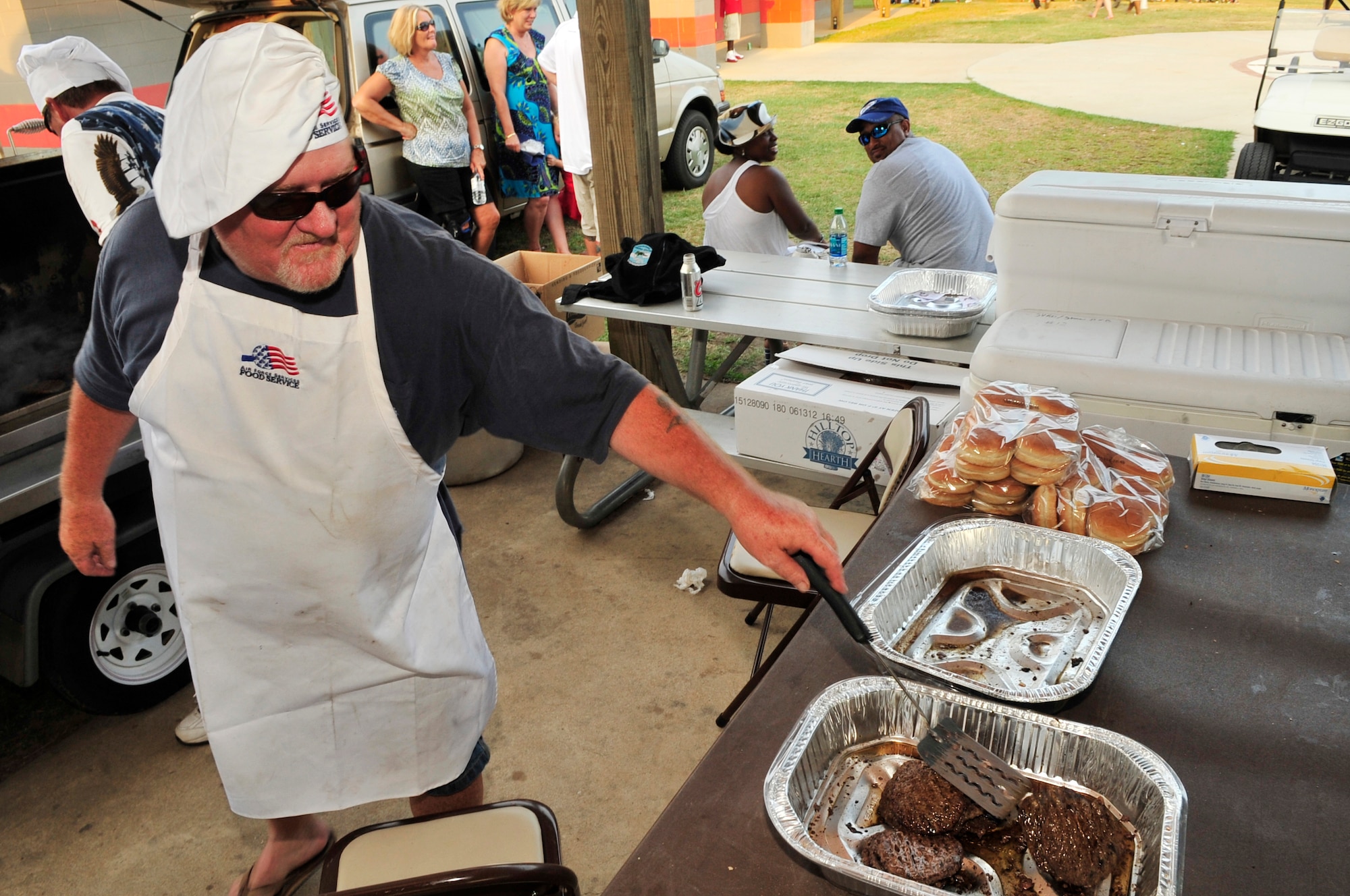 Carrie Rogers, 20th Force Support Squadron outdoor recreation director, serves hamburgers at Dillon Park, Sumter, S.C., July 4, 2012.  More than 1,000 people showed up for the fireworks display at the Jammin July Fourth.(U.S. Air Force photo by Airman Nicole Sikorski/Released)
