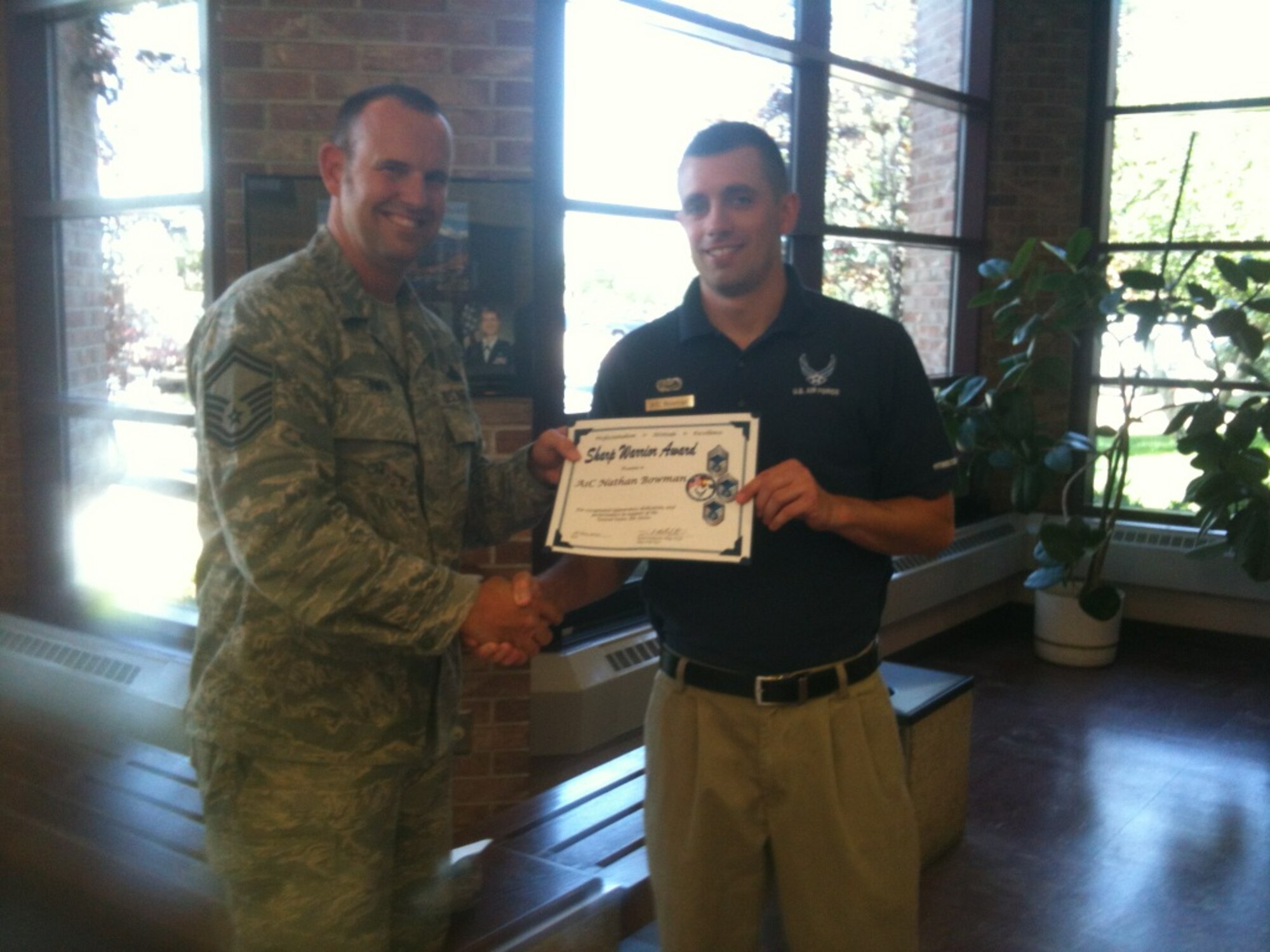 PETERSON AIR FORCE BASE, Colo. – Senior Master Sgt. Brian Smith, 21st Communications Squadron, presents the Pikes Peak Top 3 Sharp Warrior Award for May to Airman 1st Class Nathan Bowman, 21st Force Support Squadron. The award recognizes Airmen who go beyond their everyday tasks and demonstrate a high level of excellence, specifically in customer service and professional appearance. The Sharp Warrior Award is awarded each month in recognition of Team Petersons' best. (Courtesy photo)