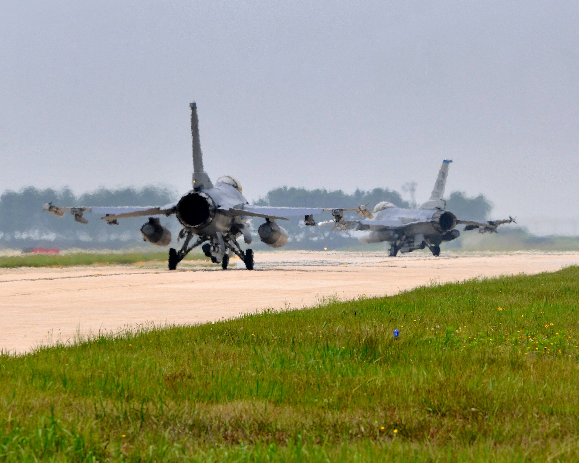 Two F-16s taxi towards the flight line preparing for take-off during exercise Beverly Midnight 12-03 on Kunsan Air Base, Republic of Korea, July 9 Jul 2012. The exercise tests the base’s deployment and operational readiness and is the first since the base unit compliance inspection in April. (U.S. Air Force photo/Staff Sgt. Jonathan Fowler)