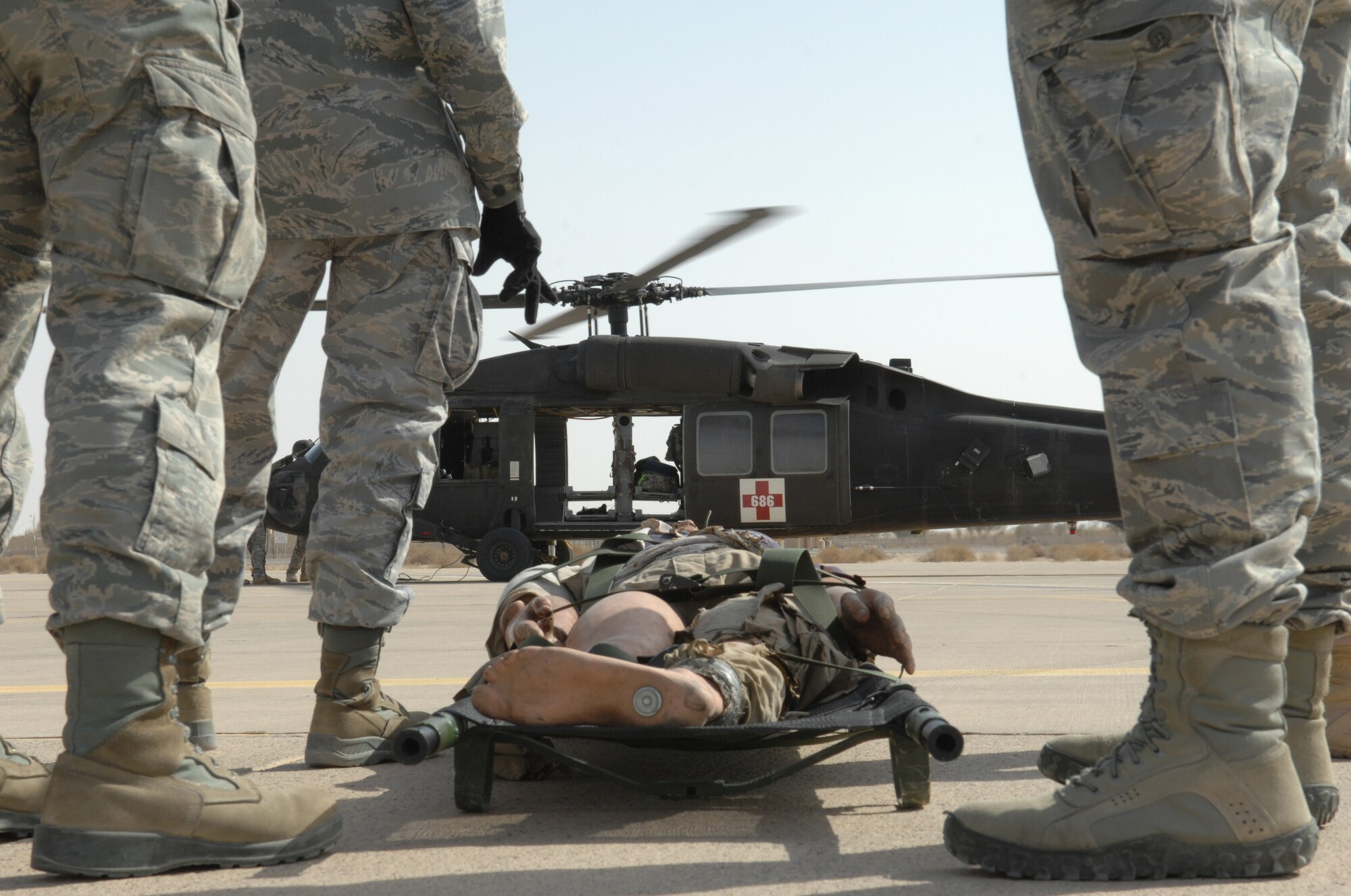 SOUTHWEST ASIA – Airmen from the 386th Expeditionary Medical Group wait as the helicopter lands and is safe to board a “casualty” during a medical evacuation training exercise. The U.S. Army Aviation Unit, General Support Aviation Battalion, gave them the opportunity to train and exercise for real-world scenarios.  (U.S. Air Force photo/Staff Sgt. Alexandra M. Boutte)
