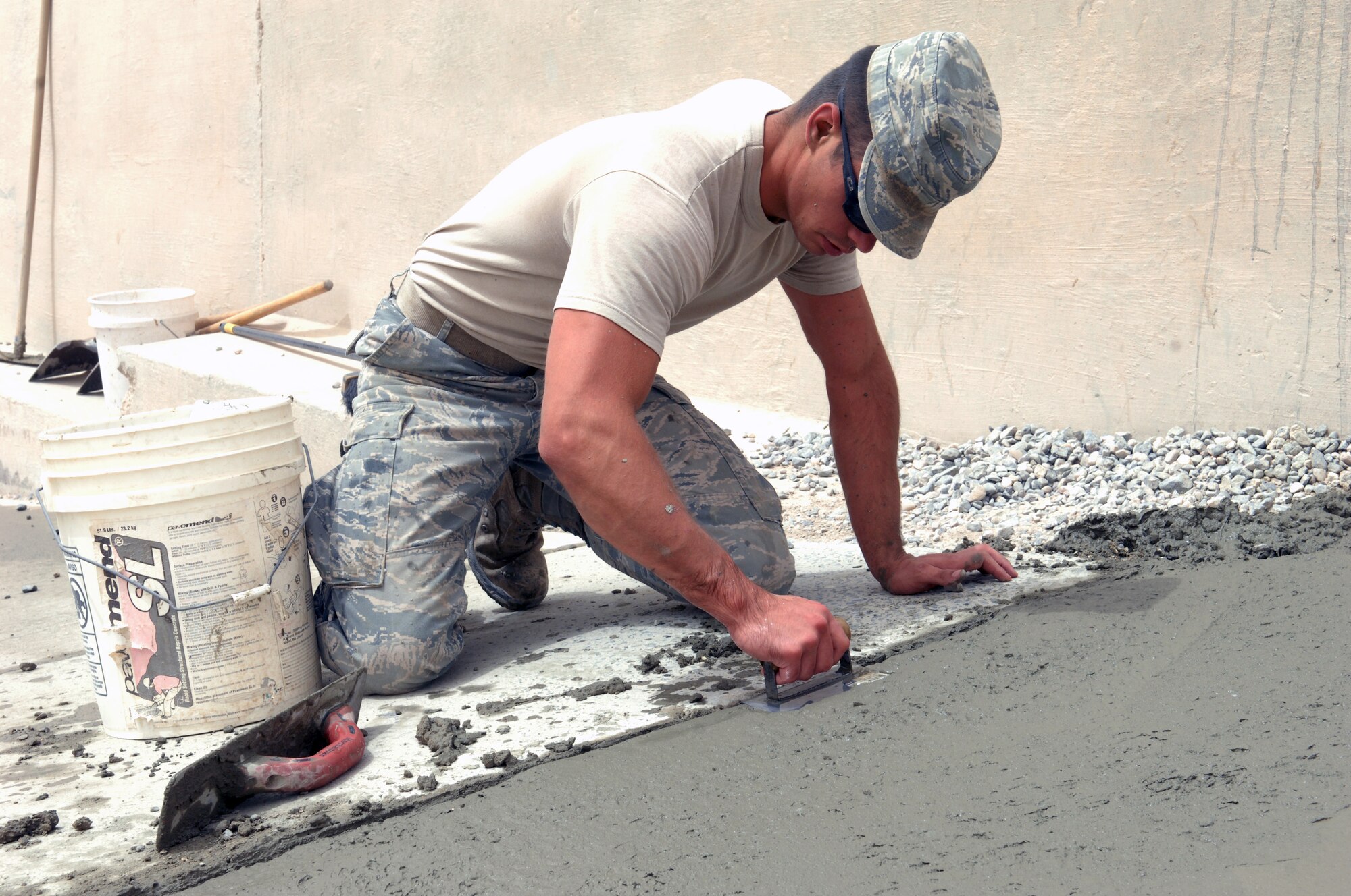 SOUTHWEST ASIA – Senior Airman David McCoy, 386th Expeditionary Civil Engineer Squadron, levels freshly poured cement on the newly renovated sidewalk at the dining facility here July 7. (U.S. Air Force photo/Staff Sgt. Alexandra M. Boutte) 