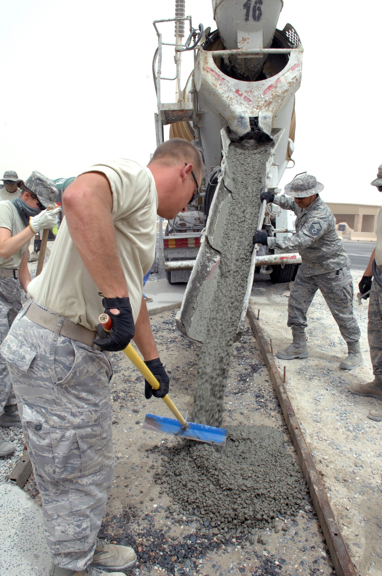 SOUTHWEST ASIA – Members of the 386th Expeditionary Civil Engineer Squadron, begin pouring cement into the foundation of a sidewalk at the dining facility here July 7. The squadron improves quality of life by building sidewalks to eliminate the hazards of walking on the rocks. (U.S. Air Force photo/Staff Sgt. Alexandra M. Boutte) 