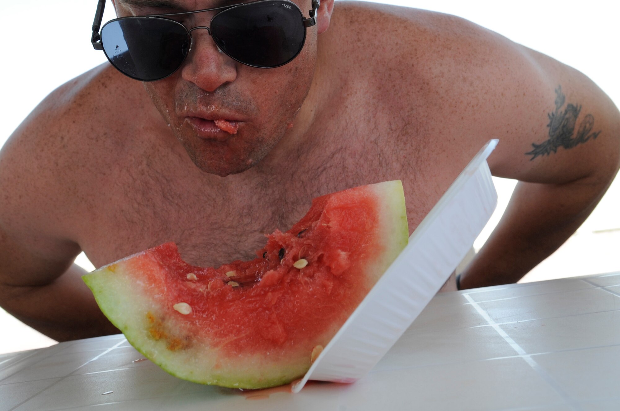 SOUTHWEST ASIA – U.S. Army Staff Sgt. Robert Winebarger, 725th Brigade Support Battalion, devours a piece of watermelon during the contest at the Freedom Fest 2012 here July 4. The participants raced to finish without using their hands. The winner was Airman 1st Class John Randall, 386th Expeditionary Communications Squadron. (U.S. Air Force photo/Staff Sgt. Alexandra M. Boutte)