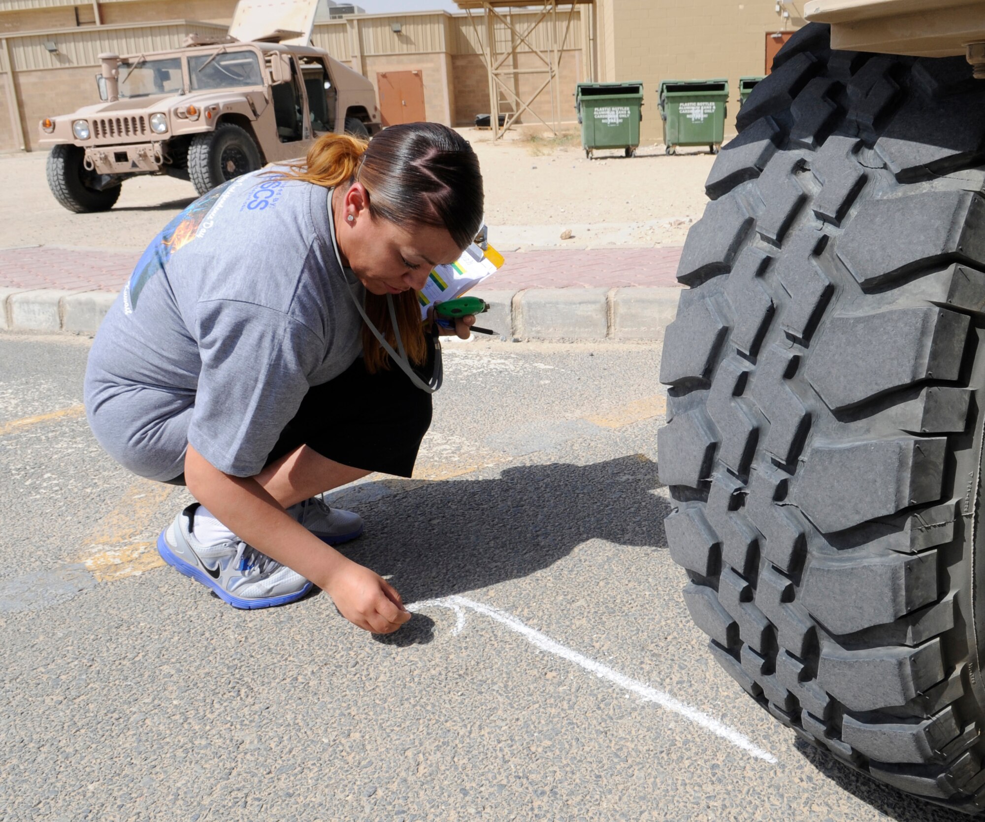 SOUTHWEST ASIA – Staff. Sgt. Raquel Johnson, 386th Expeditionary Force Support Squadron, marks the stop-point of the Humvee push contest at the Freedom Fest 2012 here July 4. Five teams of three pushed the vehicle as far as they could for 30 seconds. Senior Airman Datrell Johnson, Mark Hunter and Ebot Leonel from the 386th EFSS won the event. (U.S. Air Force photo/Staff Sgt. Alexandra M. Boutte)