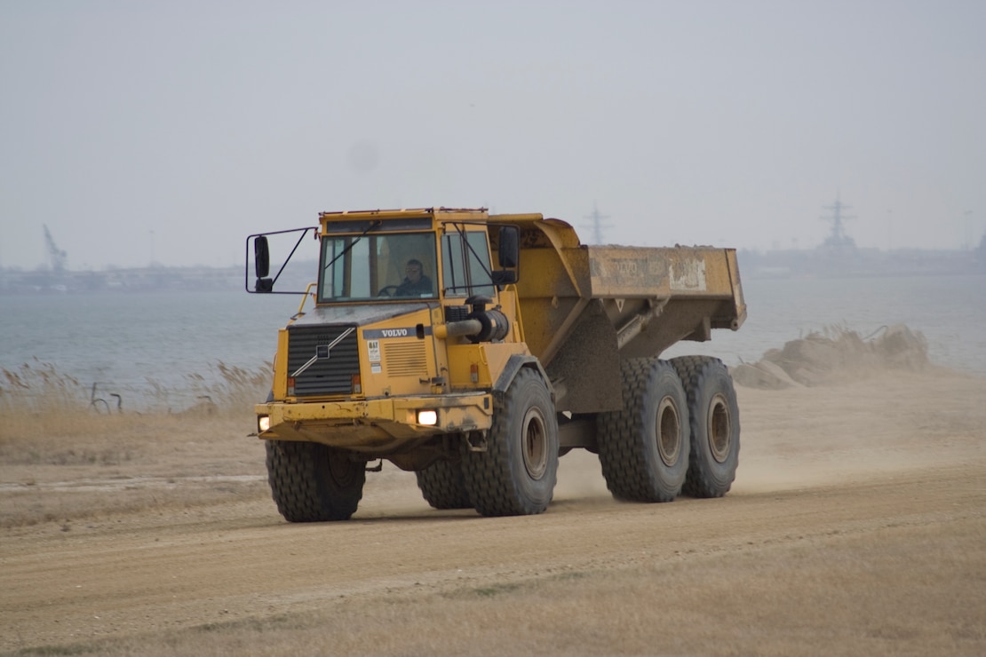 Large dump trucks move material around the Norfolk District’s Craney Island Dredged Material Management Area. The area is a 2,500-acre confined dredged material disposal site located near Norfolk, VA. Plans for the site were developed in the early 1940s to provide a long-term disposal area for material dredged from the channels and ports in the Hampton Roads area.