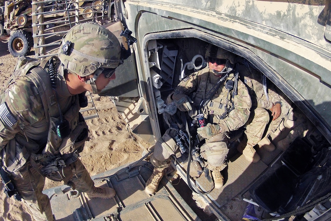 U.S. Army Spc. Caleb Spurgeon, left, talks with U.S. Army Sgt. Tim ...