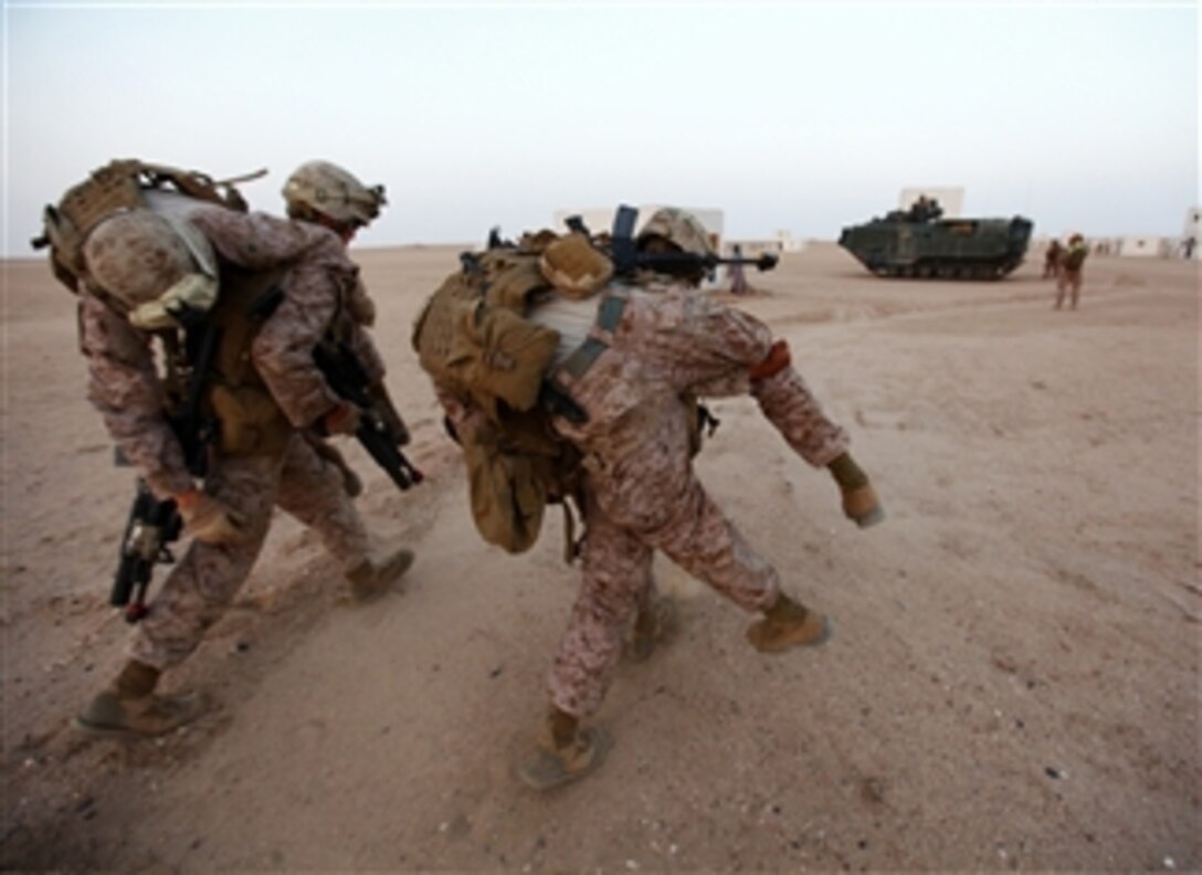U.S. Marines with Alpha Company, Battalion Landing Team 1st Battalion, 2nd Marine Regiment, 24th Marine Expeditionary Unit, carry simulated casualties to an Assault Amphibious Vehicle during a training raid at the Udairi Range in Kuwait, on June 30, 2012.  