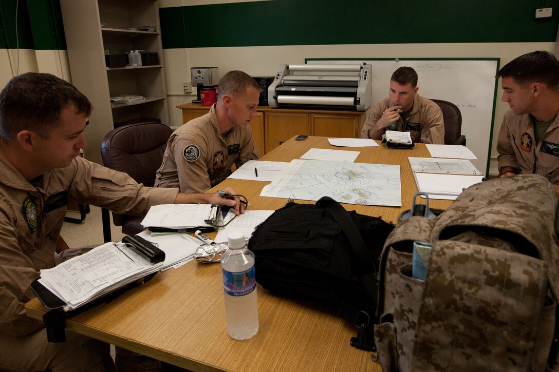 Capt. Chris Cayere, Weapons and Tactics Instructor, Marine Light Attack Helicopter Squadron 169 briefs pilots from Marine Heavy Helicopter Squadron 463 and HMLA-169 before cross-cockpit training June 7. Multiple detachments of aviation and support units will be assigned to HMH-463 (reinforced) during RIMPAC 12 to comprise the aviation combat element of Special Purpose Marine Air-Ground Task Force 3. Approximately 2,200 personnel from nine nations comprise SPMAGTF-3, Combined Force Land Component Command. The CFLCC is conducting amphibious and land-based operations in order to enhance multinational and joint interoperability.