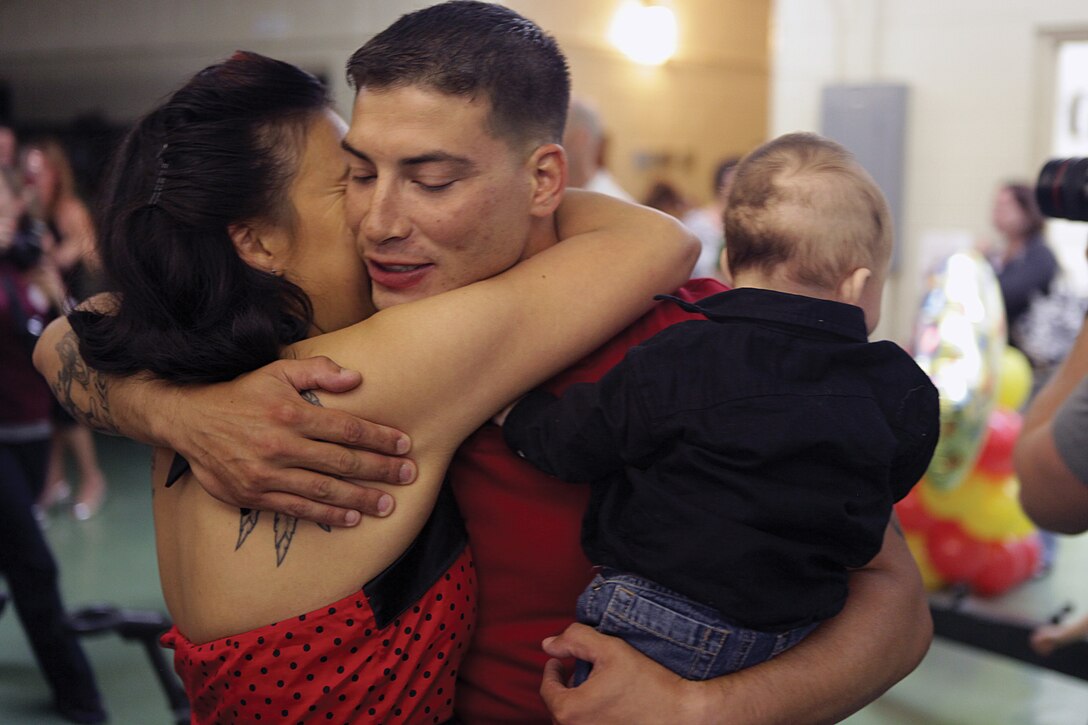 Sgt. Timmy J. Crochet hugs his wife Cassandra and son Jestin at the explosive ordnance disposal shop on Camp Hansen May 4 after returning from a six and a half-month deployment in Helmand province, Afghanistan. 3rd EOD Co. is part of 9th Engineer Support Battalion, 3rd Marine Logistics Group, III Marine Expeditionary Force. Crochet is an explosive ordnance disposal technician with 3rd EOD Co.