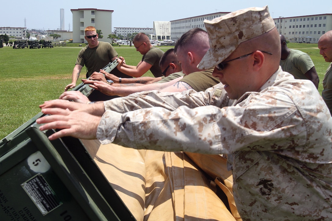 Bulk fuel specialists set up fuel bladders in preparation for an amphibious assault fuel system exercise at the Camp Hansen parade deck May 7. The Marines are with 9th Engineer Support Battalion, 3rd Marine Logistics Group, III Marine Expeditionary Force. 