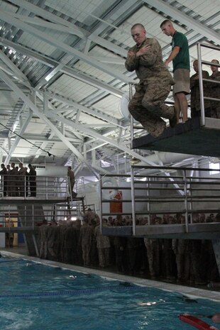 Recruits of Company E, 2nd Recruit Training Battalion practice water survival techniques aboard Marine Corps Recruit Depot San Diego July 9. Recruits were taught how to use their camouflage utilities as a floatation tool. Recruits were put through various tests to make sure they knew basic water survival skills. Exercises included a 10 foot dive followed by a 25 meter swim and four minutes of treading water.