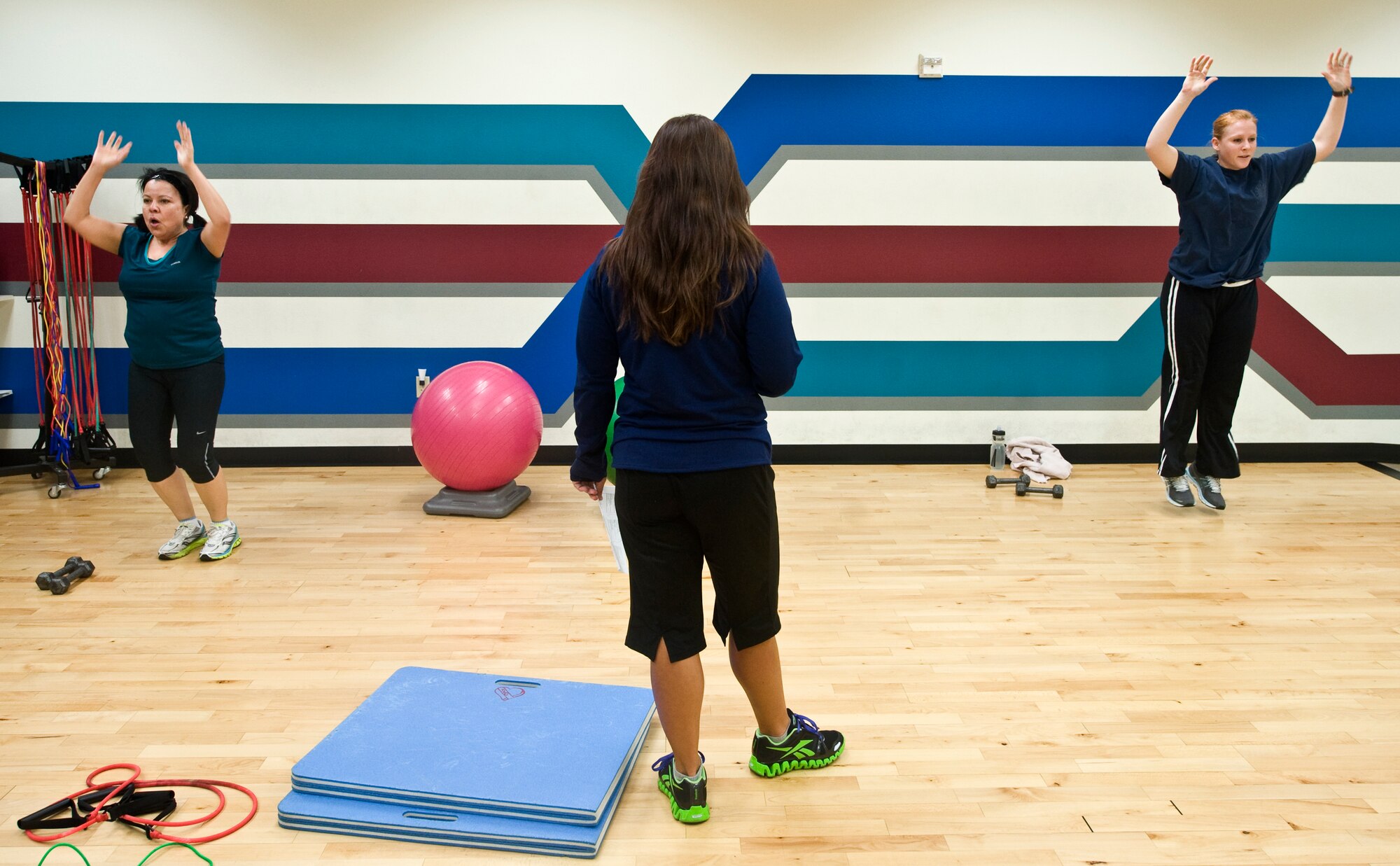 Kelley Welchart, Health and Wellness Center health and fitness specialist, instructs Margie Collyer, AFOTEC budget analysis specialist, and Christine Biederer, USAF Weapons School graphic designer, during the fitness conditioning class July 9, 2012, at Nellis Air Force Base, Nev. The class is available every Monday and Thursday at the HAWC. (U.S. Air Force photo by Staff Sgt. Christopher Hubenthal)