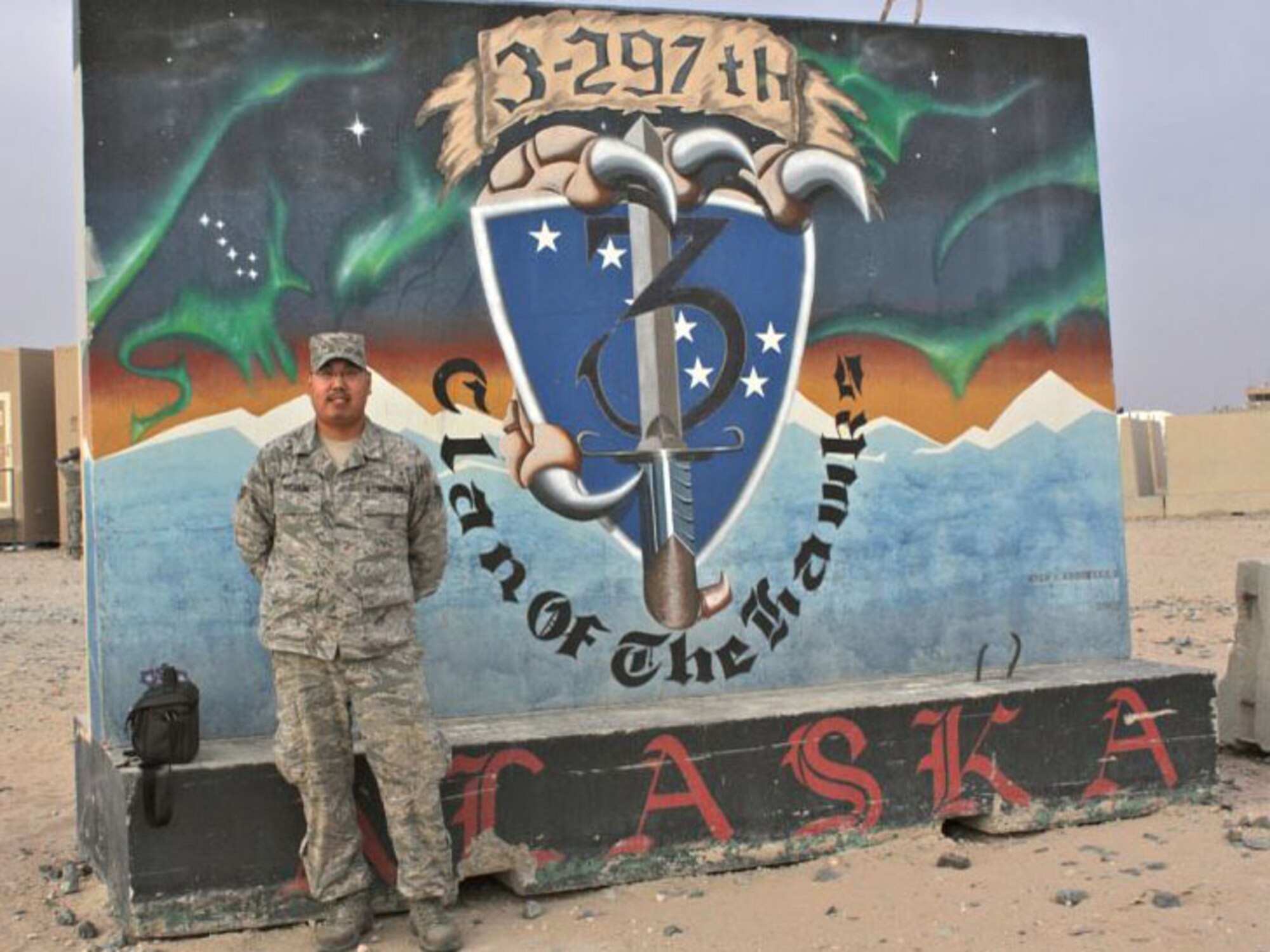 SOUTHEAST ASIA -- Alaska Air National Guardsman Senior Airman Cameron Mixsooke of Kenai, Alaska, stands in front of an Alaska National Guard mural during a recent deployument to Kuwait. Photo courtesy of Alaska Air Natinolal Guard.