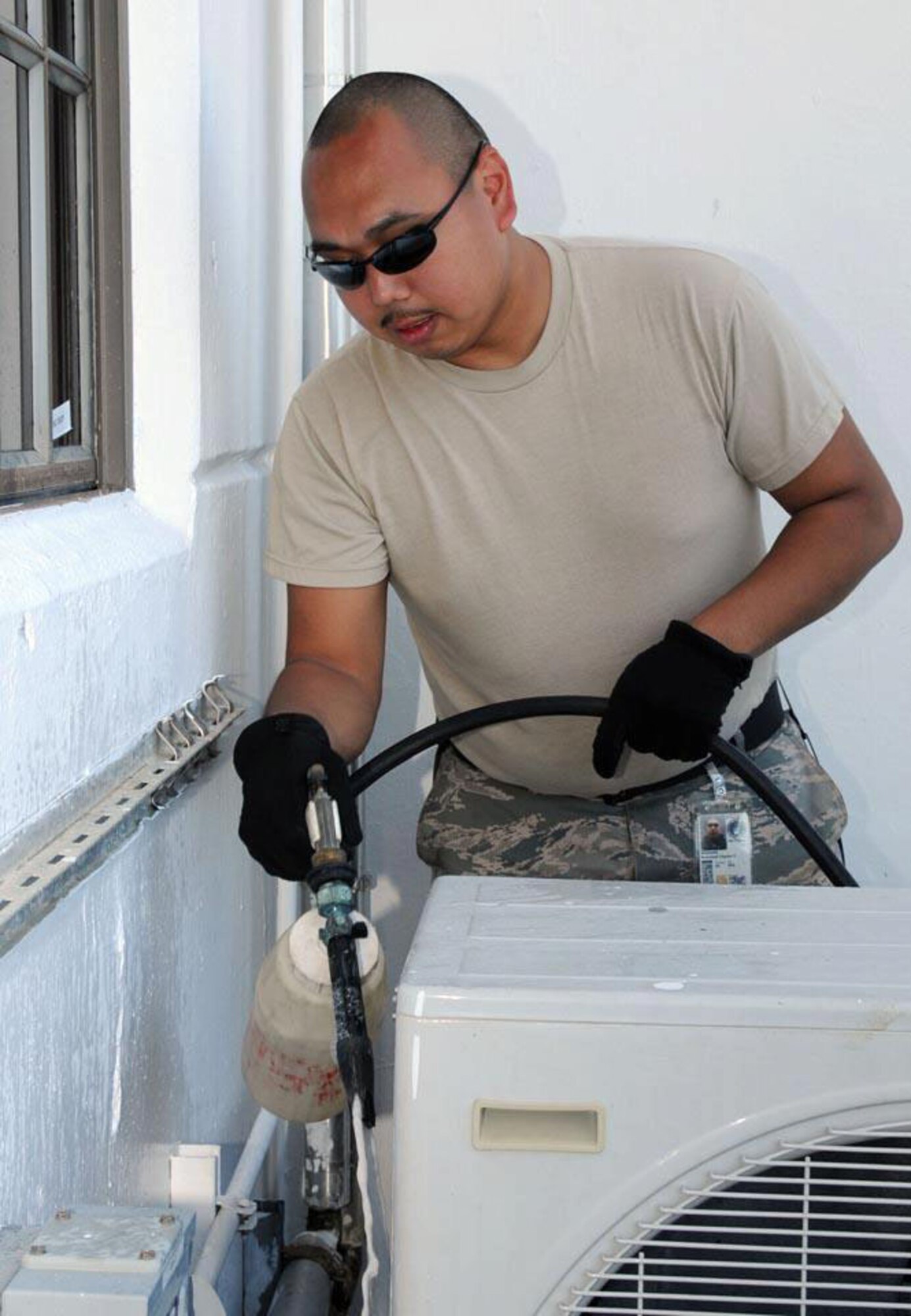 COAST GURAD AIR STATION BORINQUEN, Puerto Rico -- Senior Airman Cameron Mixsooke works on an air conditioning unit outside a Coast Guard hangar Feb. 9, 2010, during a Deployment For Training here with the 176 Civil Engineer Squadron. Mixsooke kept us skills fresh to be ready when called upon. National Guard photo by Capt. John Callahan.