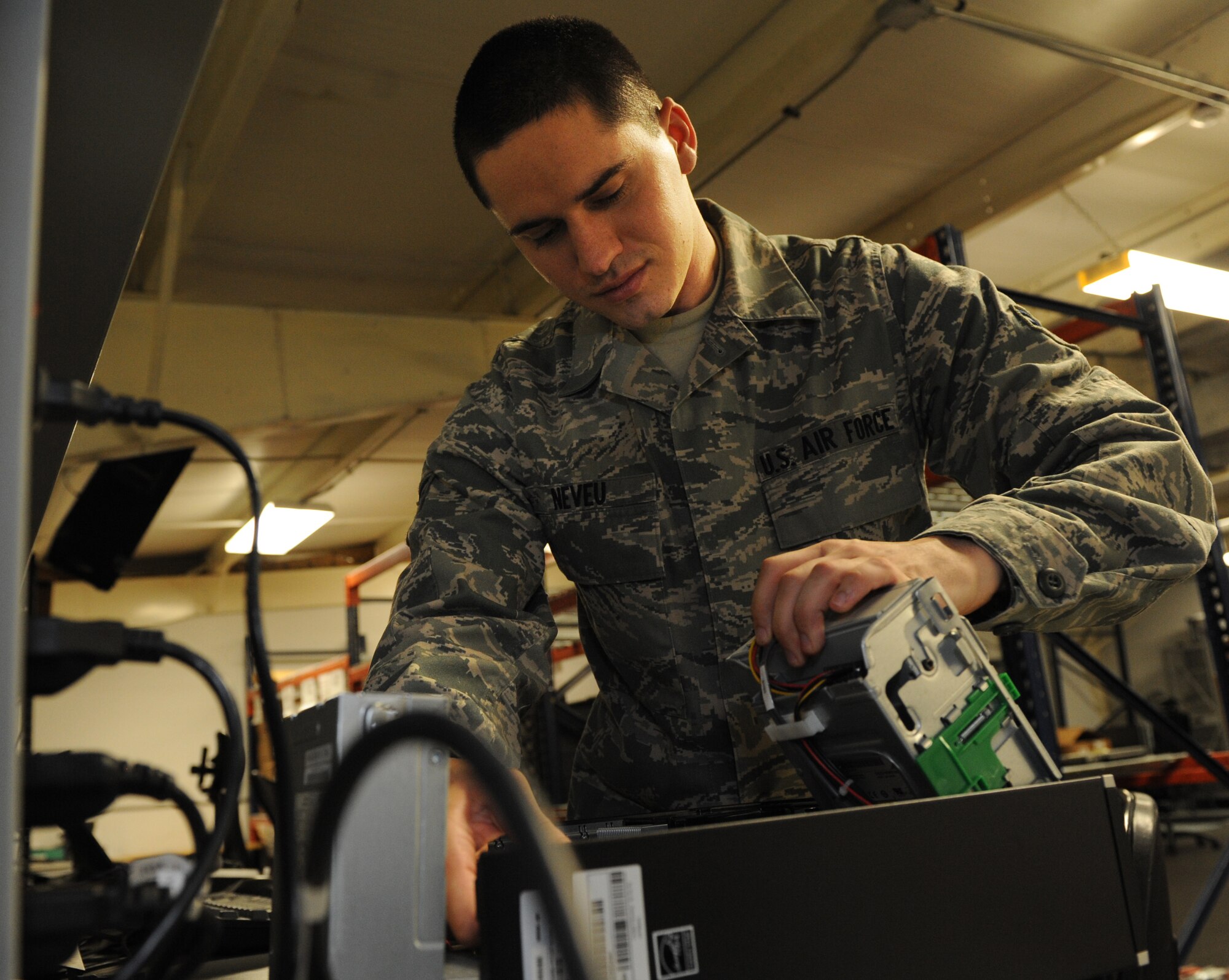 Airman 1st Class Nickolas Neveu, 22nd Communications Squadron client systems technician, replaces computer hard drive July 11, 2012, McConnell Air Force Base, Kan. Neveu was selected as the 22nd Air Refueling Wing Spotlight performer for the week of July 9 to 13, 2012. As a spotlight performer, individuals are chosen by leadership for demonstrating one or more of the 22nd ARW commander's intents which include fostering a culture of excellence, developing the next generation of leaders and setting and achieving goals. (U.S. Air Force photo/Airman 1st Class Katrina M. Brisbin)