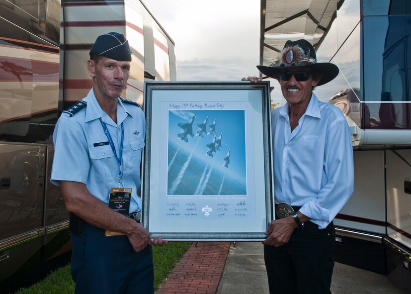 U.S. Air Force Lt. Gen. Stanley Clarke, Continental U.S. North American Aerospace Defense Command Region -- 1st Air Force (Air Forces Northern) commander, presents a lithograph signed by the U.S. Air Force Thunderbirds to former NASCAR driver Richard Petty for his 75th birthday July 7, 2012, at the Daytona International Speedway, Daytona Beach, Fla. (U.S. Air Force photo by Senior Airman Eileen Meier/Released)