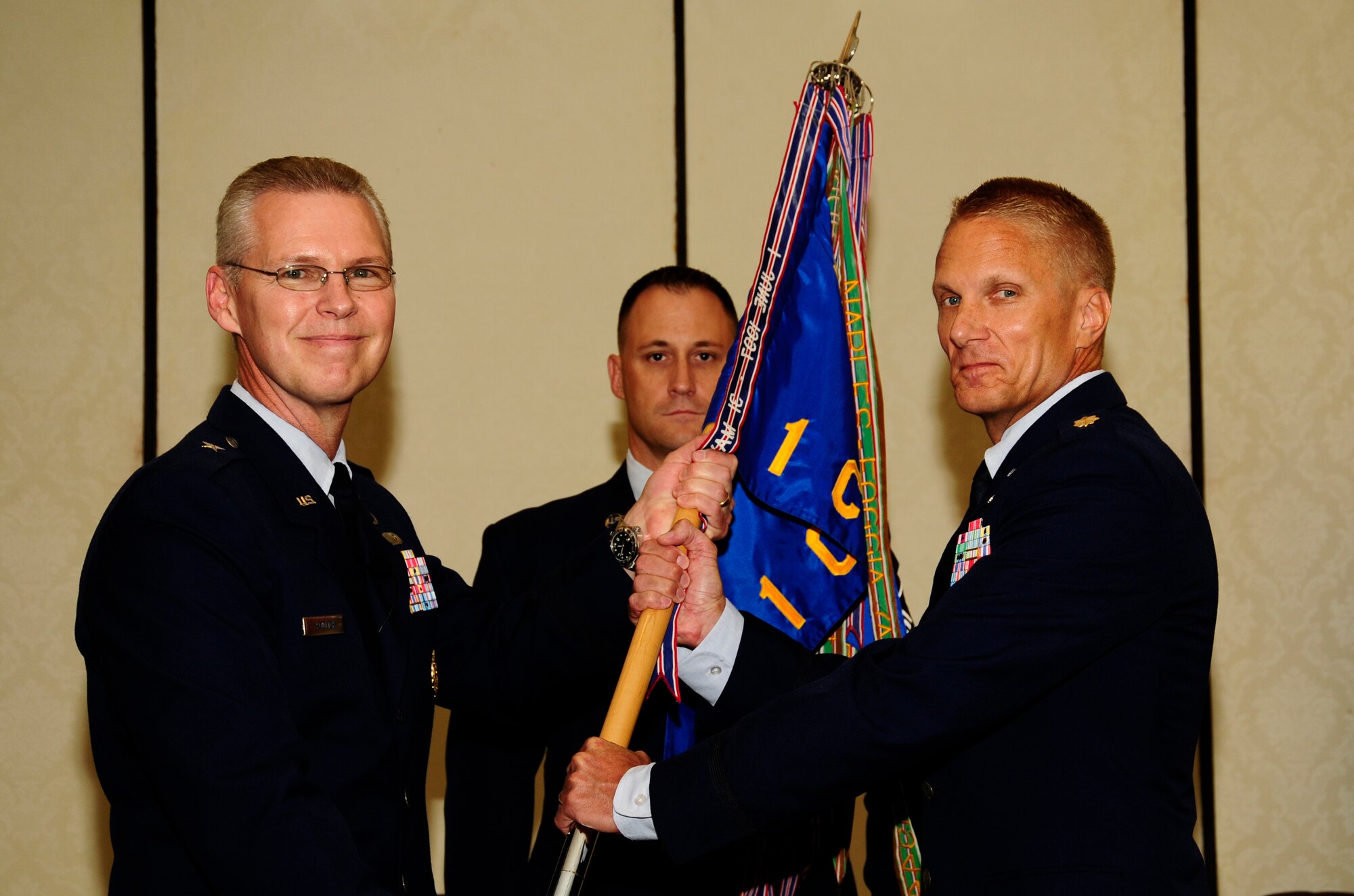 U.S. Air Force Maj. Michael Johnson assumes command of the 1st Combat Camera Squadron from U.S. Air Force Brig. Gen. Les Kodlick, Office of the Secretary of the Air Force Director of Public Affairs, during a change of command ceremony at Joint Base Charleston, S.C., July 10. (U.S. Air Force Photo by Senior Airman Alexandra Hoachlander/ Released)