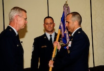 U.S. Air Force Lt. Col. Aaron Burgstien relinquishes command of the 1st Combat Camera Squadron to U.S. Air Force Brig. Gen. Les Kodlick, Office of the Secretary of the Air Force Director of Public Affairs, during a change of command ceremony at Joint Base Charleston, S.C., July 10. (U.S. Air Force Photo by Senior Airman Alexandra Hoachlander/ Released)