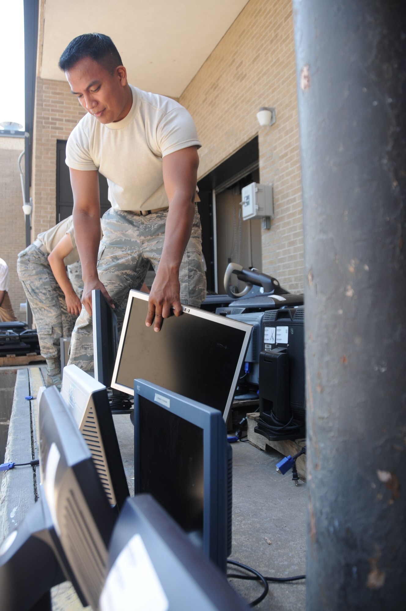 Senior Airman Henry Bones, 81st Communications Squadron, separates computer monitors as they are unloaded at the Locker House June 27, 2012, at Keesler Air Force Base, Miss. The monitor turn in is part of a program started by the 81st Communications Squadron  Management information technology section to rid the base of excess IT assets.  A total of 1200 plus monitors where turned in and transferred to other equipment custodians to be used in their squadrons or donated to local schools.  (U,S. Air Force photo by Kemberly Groue)