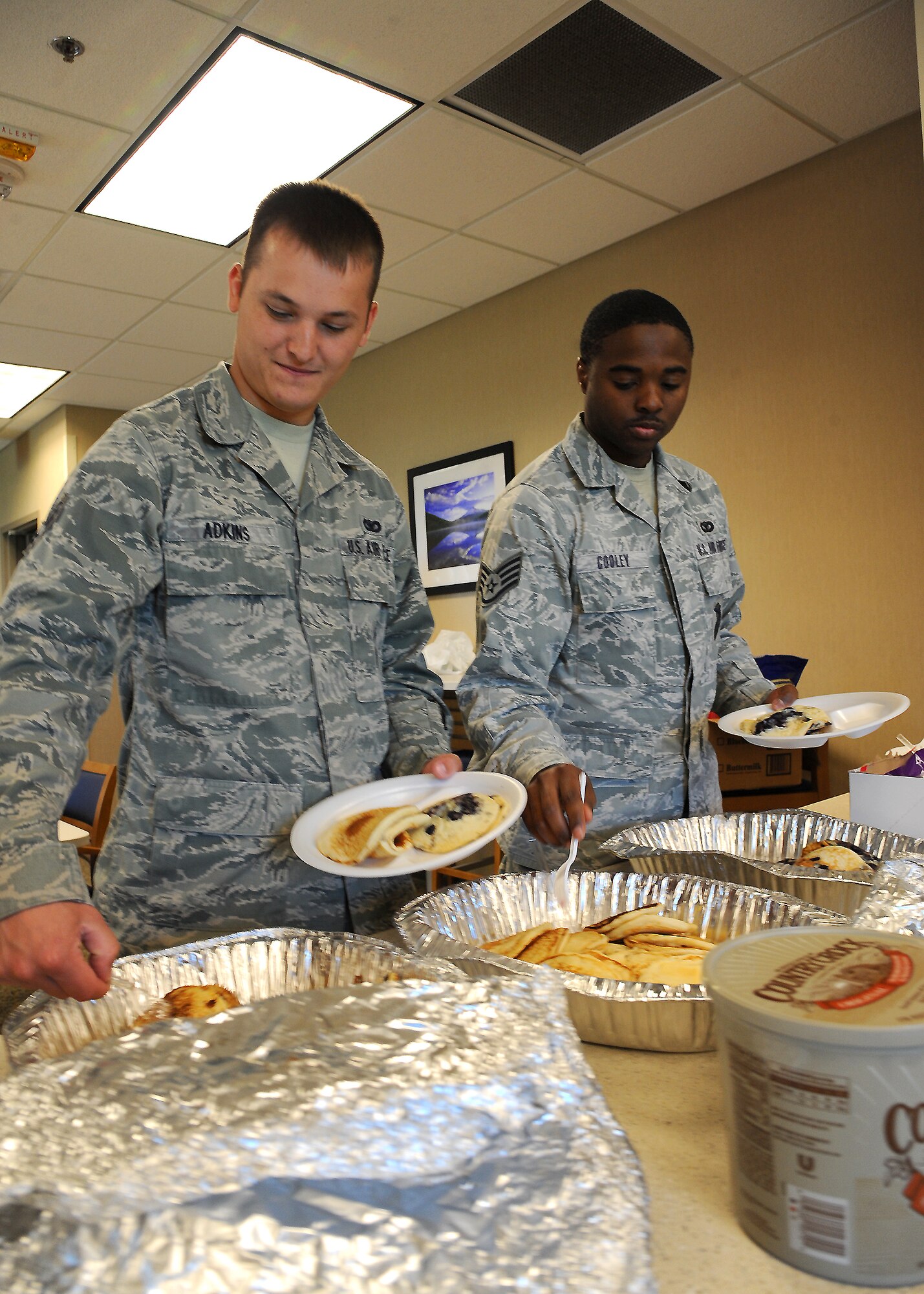 Senior Airman Clifton Adkins Jr. and Staff Sgt. Louis Cooley, 319th Security Forces Squadron, help themselves to pancakes during the Wounded Warrior Pancake Feed on July 11, 2012, on Grand Forks Air Force Base, N.D.  The event was sponsored by the Top 3 Association and raised $600 for the Wounded Warrior Foundation.  (U.S. Air Force photo by Airman 1st Class Xavier Navarro)