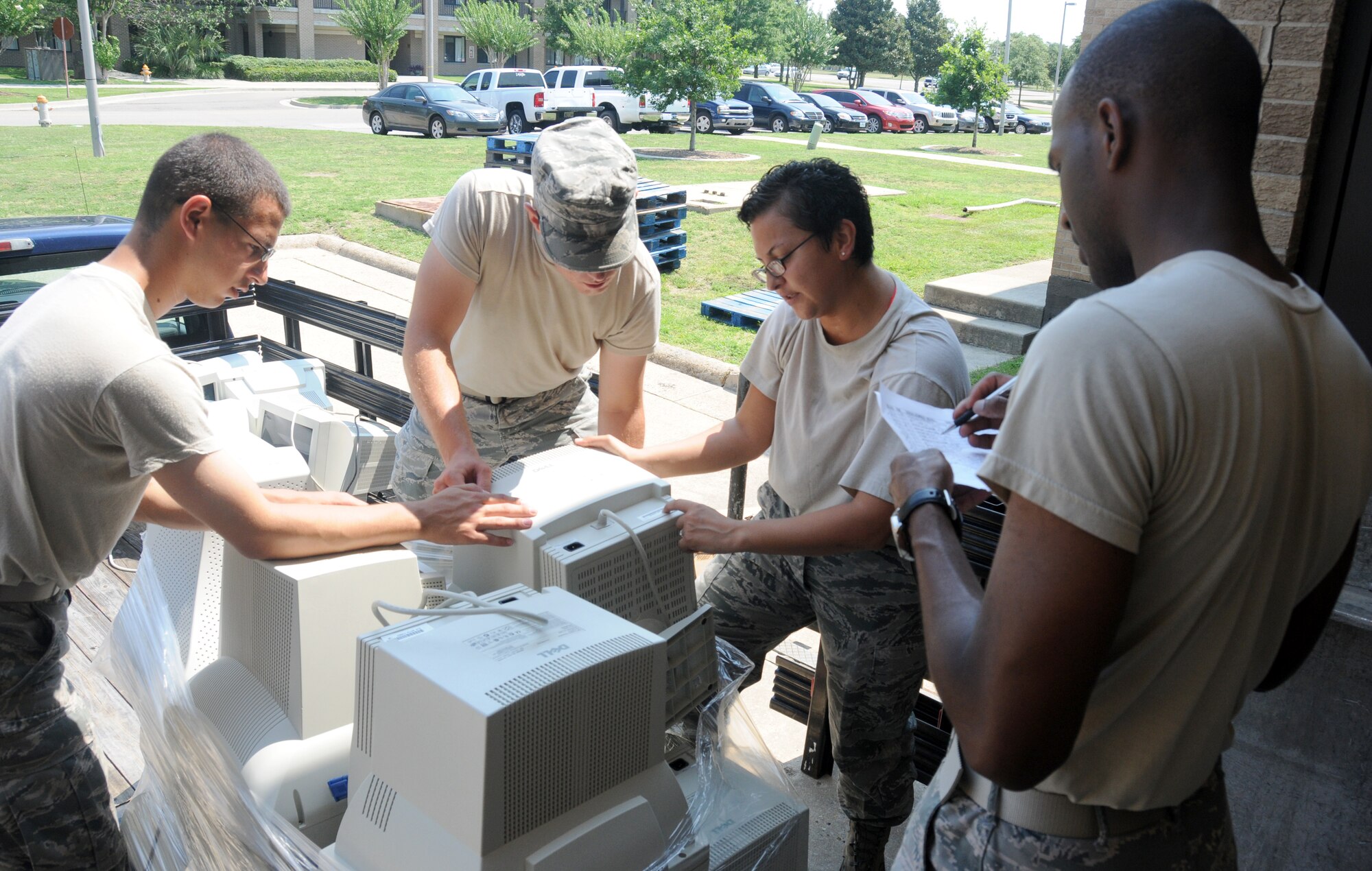 Senior Airmen Joshua Davis, 335th Training Squadron, and Patrick Castro, 81st Communications Squadron, Staff Sgt. Iris Palmer, 335 TRS, and Senior Airman Kenneth Thomas, 81 CS, verify serial numbers on the information technology equipment turned in by the 335 TRS at the Locker House June 27, 2012, at Keesler Air Force Base, Miss. The monitor turn in is part of a program started by the 81st Communications Squadron  Management information technology section to rid the base of excess IT assets.  A total of 1200 plus monitors where turned in and transferred to other equipment custodians to be used in their squadrons or donated to local schools. (U.S. Air Force photo by Kemberly Groue)