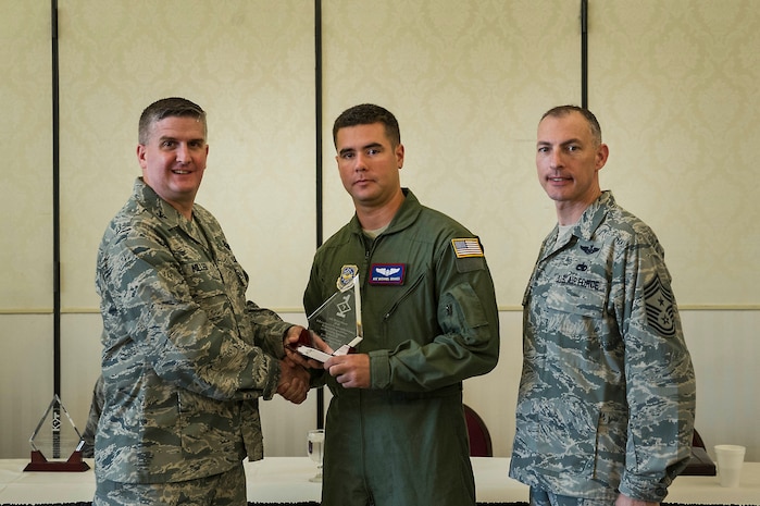 Col. Al Miller, 437th Airlift Wing vice commander, presents a Diamond Sharp award to Airman 1st Class Michael Graves, 15th Airlift Squadron loadmaster, along with Chief Master Sgt. Larry Williams, 437th AW command chief, at Joint Base Charleston - Air Base, S.C., July 10, 2012. Diamond Sharp awards are designed to recognize individuals in a unit who stand out to their first sergeant. (U.S. Air Force photo by Airman 1st Class George Goslin/Released)