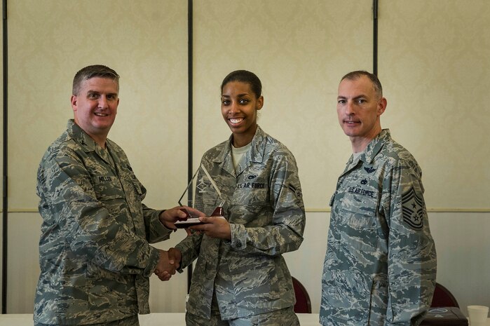 Col. Al Miller, 437th Airlift Wing vice commander, presents a Diamond Sharp award to Airman 1st Class Dawne-Kortnye Knox, 437th Maintenance Squadron Precision Measurement Equipment Laboratory Technician, along with Chief Master Sgt. Larry Williams, 437th AW command chief, at Joint Base Charleston - Air Base, S.C., July 10, 2012. Diamond Sharp awards are designed to recognize individuals in a unit who stand out to their first sergeant. (U.S. Air Force photo by Airman 1st Class George Goslin/Released)