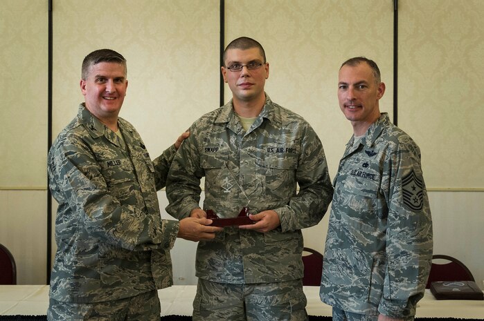 Col. Al Miller, 437th Airlift Wing vice commander, presents a Diamond Sharp award to Airman 1st Class Ryan Swapp, 437th Aircraft Maintenance Squadron aircraft flight instruments and navigation systems apprentice, along with Chief Master Sgt. Larry Williams, 437th AW command chief, at Joint Base Charleston - Air Base, S.C., July 10, 2012. Diamond Sharp awards are designed to recognize individuals in a unit who stand out to their first sergeant. (U.S. Air Force photo by Airman 1st Class George Goslin/Released)