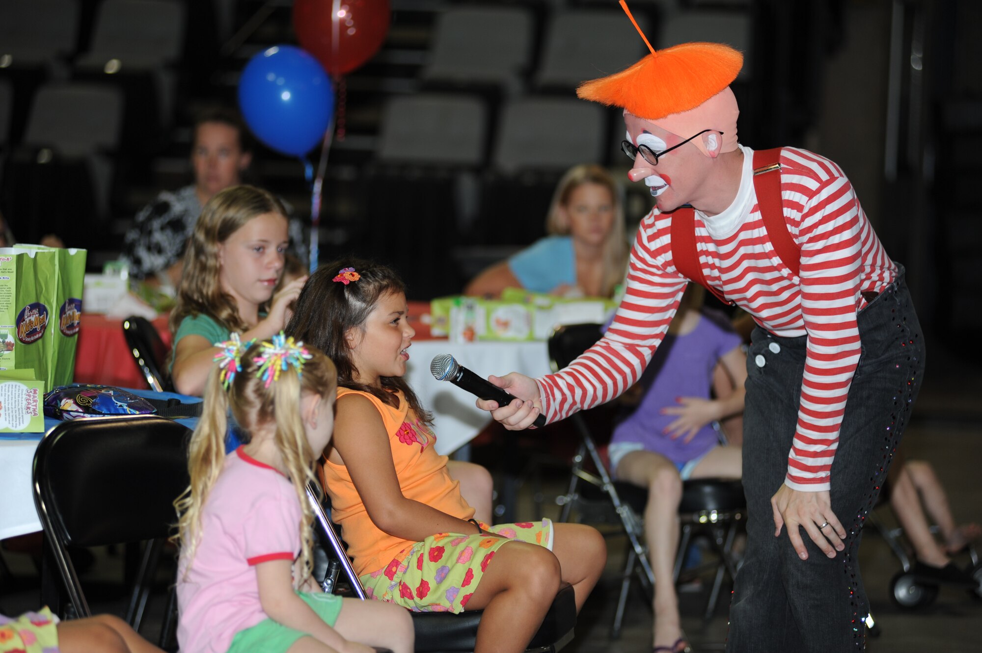 Six-year-old Piper Selah, daughter of Breanne and Capt. Trenton Selah, 345th Airlift Squadron, asks Dean the Clown, a member of the Ringling Brothers and Barnum and Bailey Circus, a question about their show elephants July 5, 2012, at the Mississippi Coast Coliseum.  The circus invited the children of deployed troops from Keesler Air Force Base, Miss., to learn about circus style exercises and received healthy eating tips that their elephants follow.  They also received free tickets to the show.  (U.S. Air Force photo by Kemberly Groue)