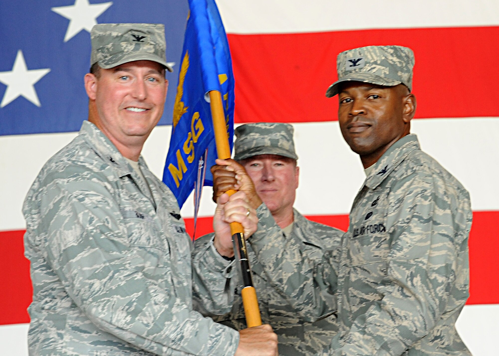 Col. Tim Bush, 319th Air Base Wing commander, passes the 319th Mission Support Group guidon to Col. Joe Lindsey during a change of command ceremony on July 11, 2012, on Grand Forks Air Force Base, N.D.  Lindsey assumed command of the 319th MSG from Col. Tammy Knierim.  (U.S. Air Force photo by Senior Airman Amber Bennett)