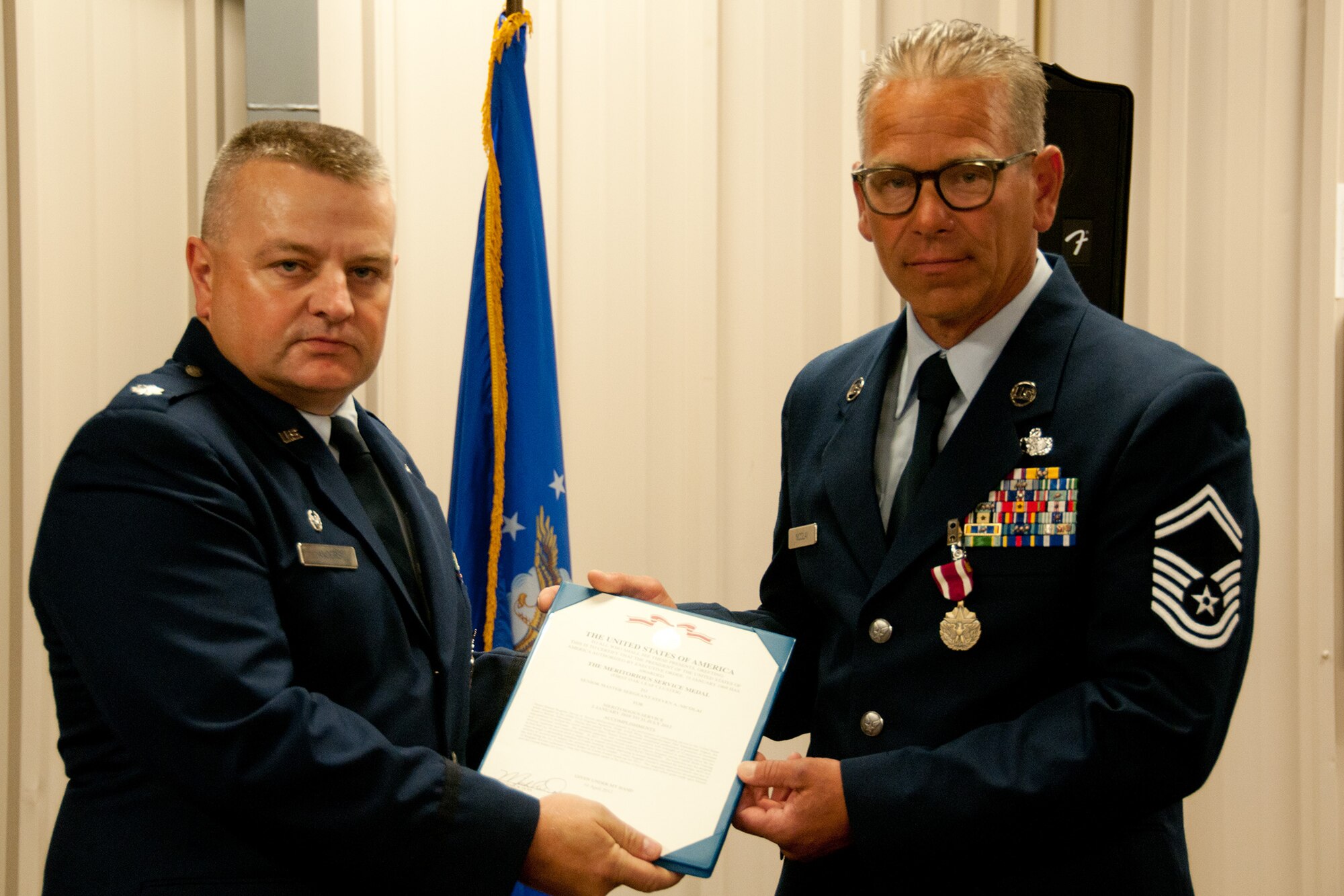 Lt. Col. Bryan G. Anders, commander of the 934th Civil Engineering Squadron, presents Senior Master Sgt. Steven Nicholai his Meritorious Service award certificate.  (U.S. Air Force Photo/ Staff Sgt. Samantha Wagner)