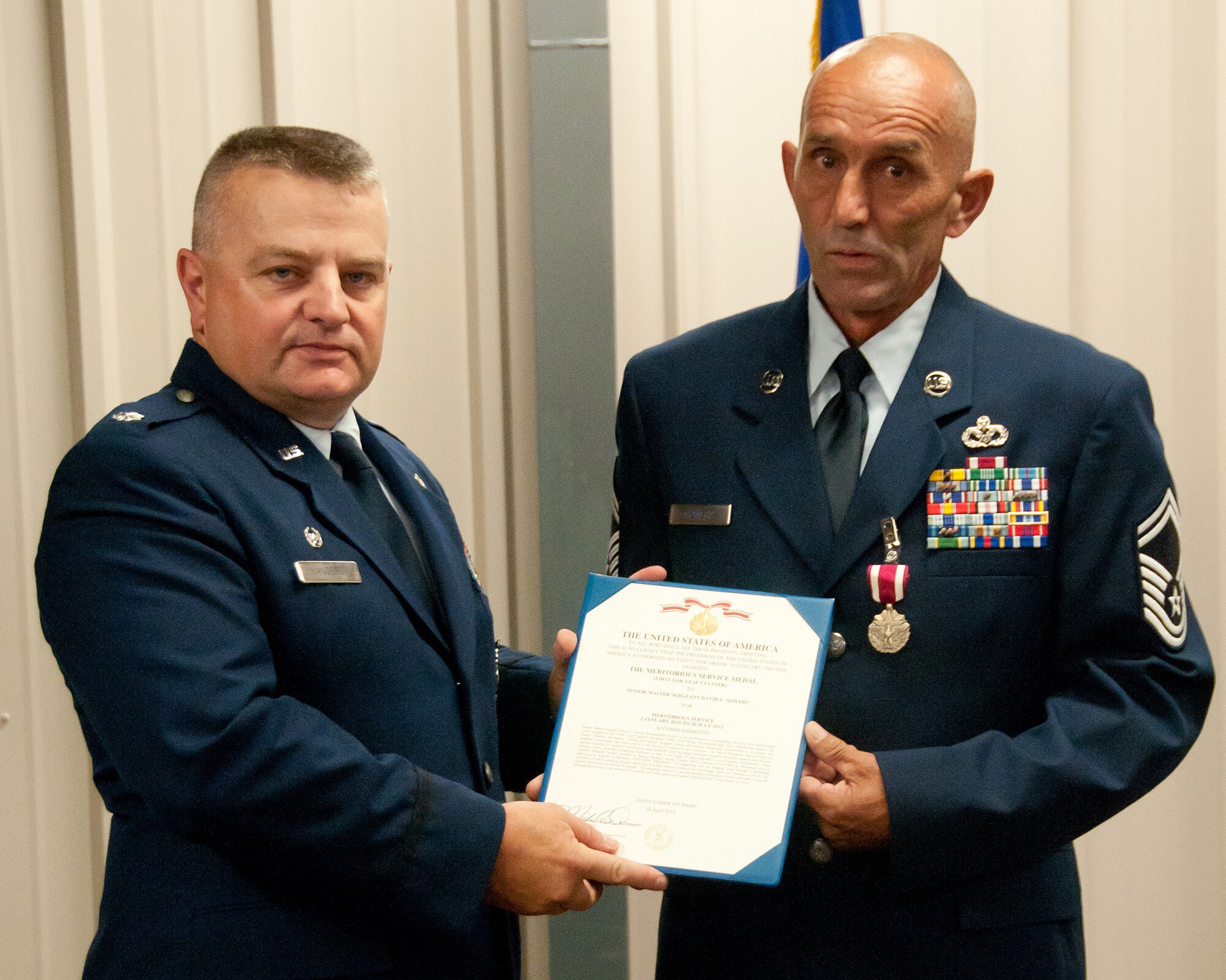 Lt. Col. Bryan G. Anders, commander of the 934th Civil Engineering Squadron, presents Senior Master Sgt. David L. Sowers with his Meritorious Service award certificate at the Minneapolis-St. Paul Air Station, Minn.  (U.S. Air Force Photo/ Staff Sgt. Samantha Wagner)