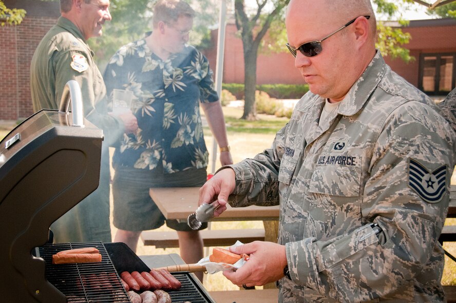 Tech. Sgt. Christopher E. Rayburn mans the grill for the 934th Airlift Wing's first Honorary Commanders and Base Community Council picnic July 7.  The HC and BCC programs help strengthen community partnerships with the 934 AW, Minneapolis-St. Paul Air Reserve Station, Minn.  (U.S. Air Force Photo/Staff Sgt. Samantha Wagner)