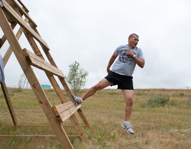 Maj. David Burnett, 28th Force Support Squadron commander, leaps off a wooden obstacle during the Commando Challenge 5k obstacle course at the Buffalo Chip Campground near Sturgis, S.D., July 7, 2012. The Commando Challenge, open to all military members and their families, was designed to test the competitor’s strength and endurance. (U.S. Air Force photo by Airman 1st Class Alystria Maurer/Released)