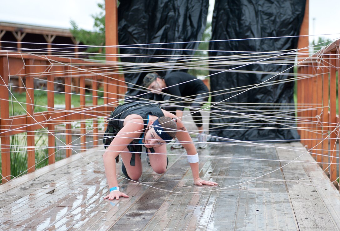 Tech. Sgt. Brandie Schoellerman, a nuclear medicine science specialist assigned to the 82nd Civil Support Squadron at Ellsworth Air Force Base, S.D., crawls through an obstacle during the Commando Challenge 5k obstacle course at the Buffalo Chip Campground near Sturgis, S.D., July 7, 2012. This event, conducted by the 28th Force Support Squadron Airman and Family Readiness Center, focused on the four pillars of wellness. (U.S. Air Force photo by Airman 1st Class Alystria Maurer/Released)