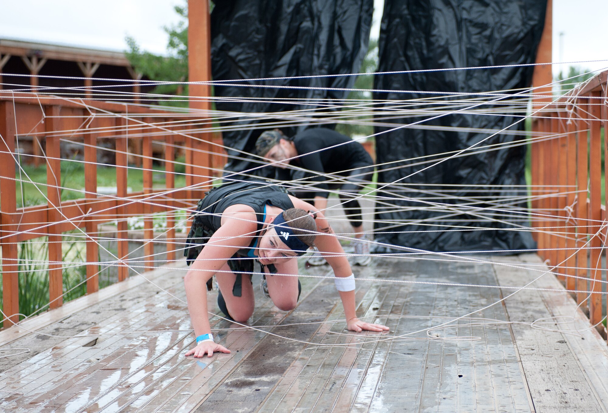Tech. Sgt. Brandie Schoellerman, a nuclear medicine science specialist assigned to the 82nd Civil Support Squadron at Ellsworth Air Force Base, S.D., crawls through an obstacle during the Commando Challenge 5k obstacle course at the Buffalo Chip Campground near Sturgis, S.D., July 7, 2012. This event, conducted by the 28th Force Support Squadron Airman and Family Readiness Center, focused on the four pillars of wellness. (U.S. Air Force photo by Airman 1st Class Alystria Maurer/Released)