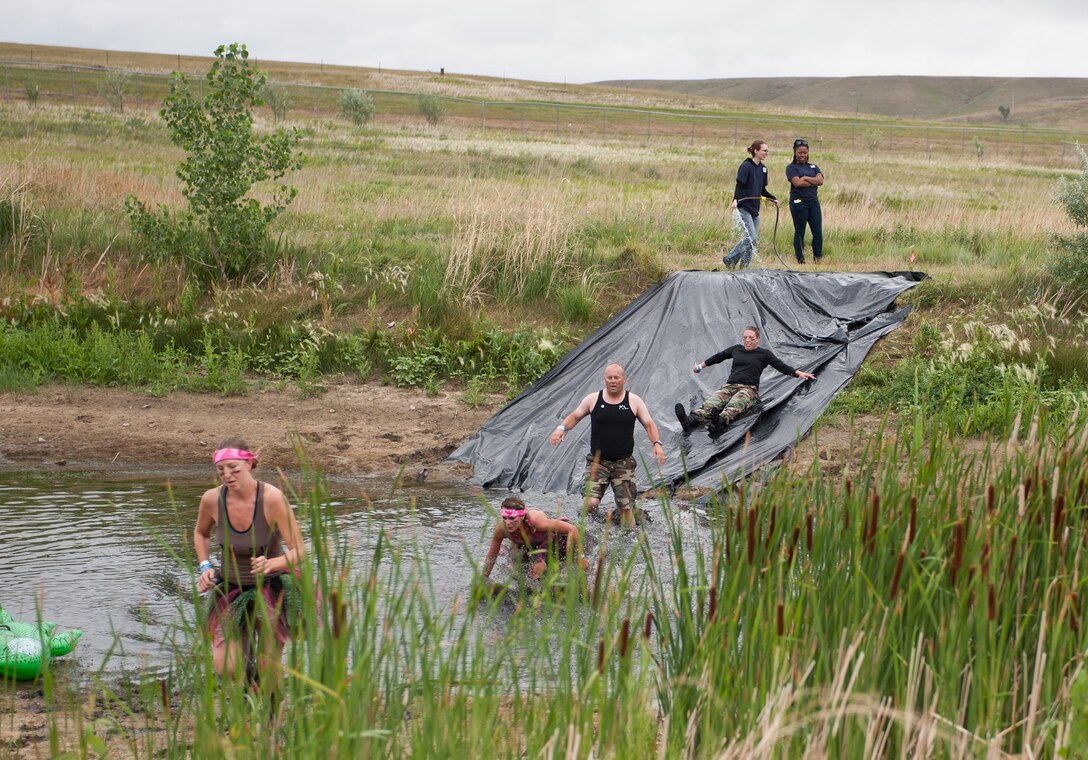 Competitors slide into a pond during the Commando Challenge 5k obstacle course at the Buffalo Chip Campground near Sturgis, S.D., July 7, 2012. The event included a competition round and multiple rounds conducted throughout the day just for fun and fitness. (U.S. Air Force photo by Airman 1st Class Alystria Maurer/Released)